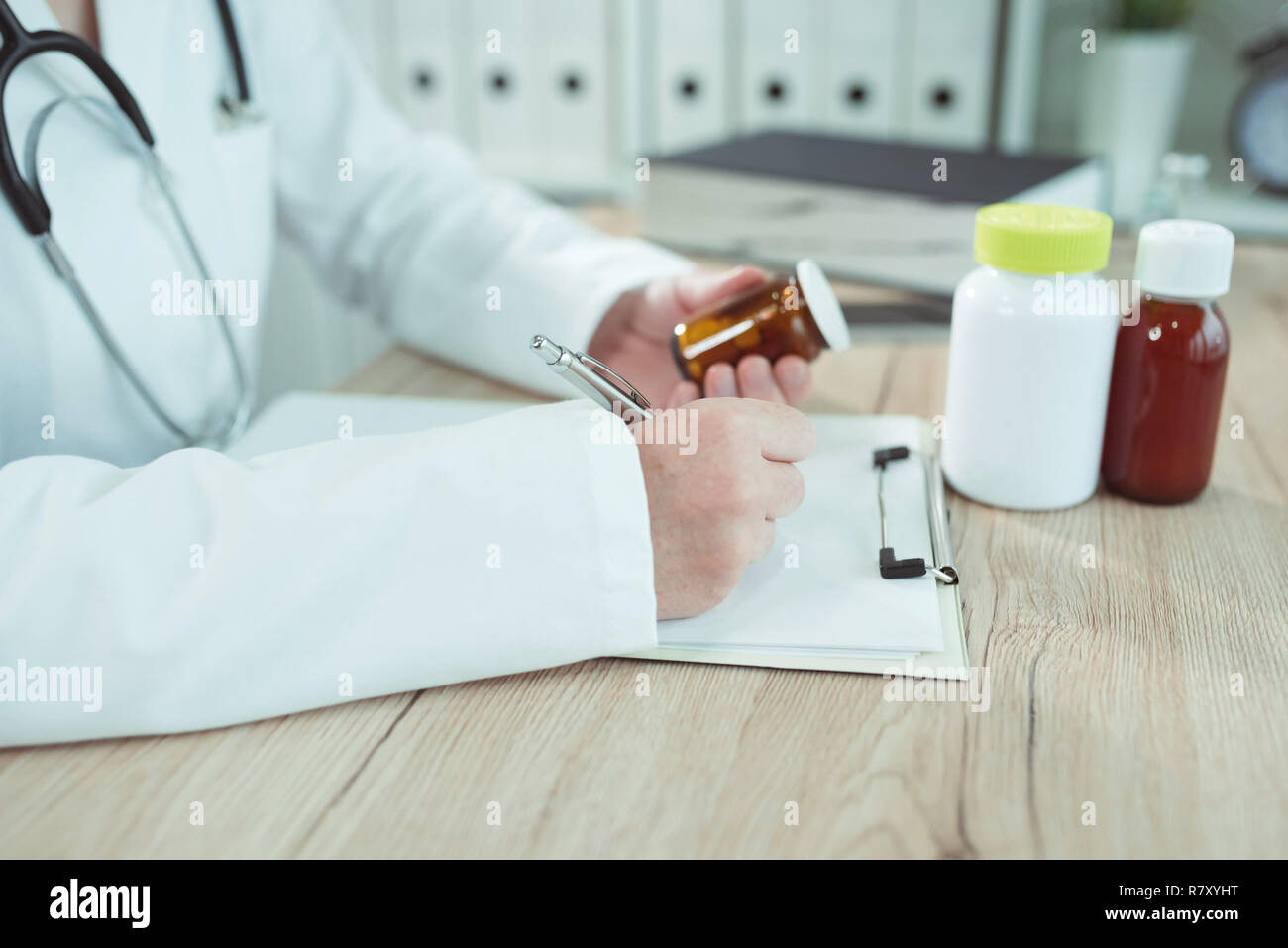Doctor writing prescription for generic drugs in medical office Stock Photo