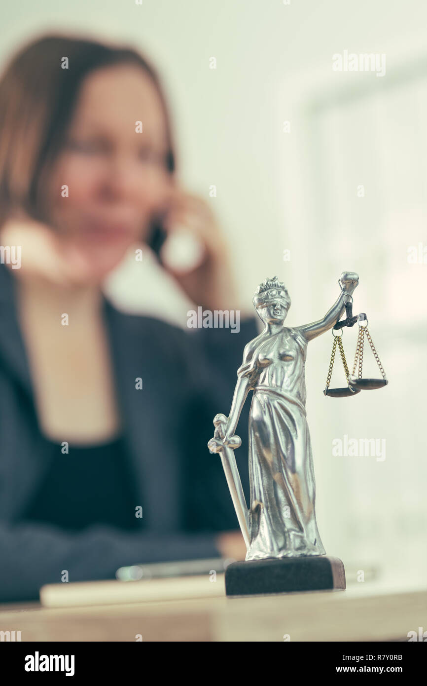 Attorney woman talking on mobile phone from her office desk, selective