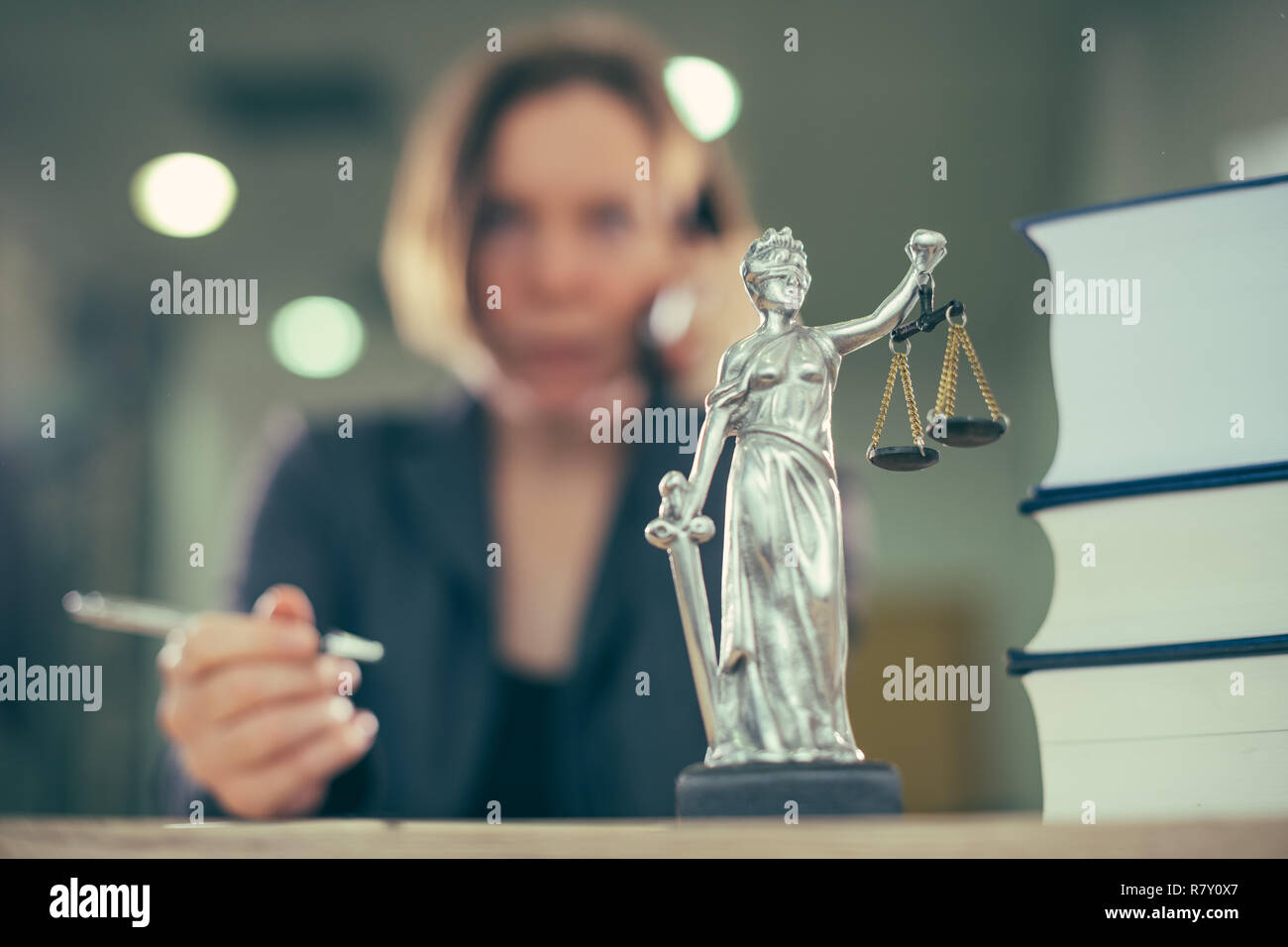 Attorney woman talking on mobile phone from her office desk, selective focus Stock Photo