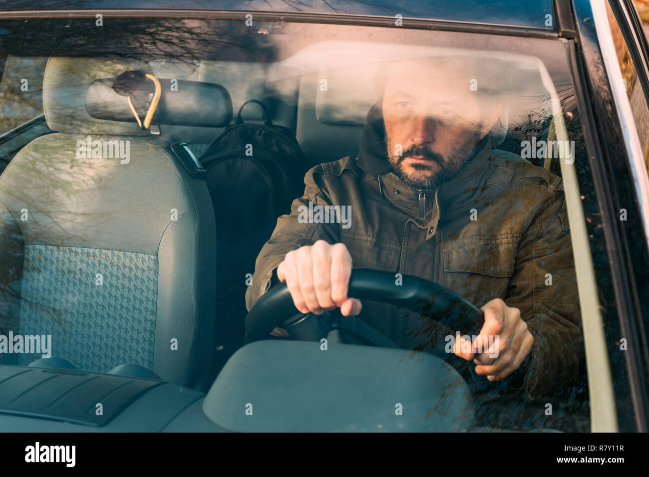 Front view of man holding steering wheel and driving car Stock Photo