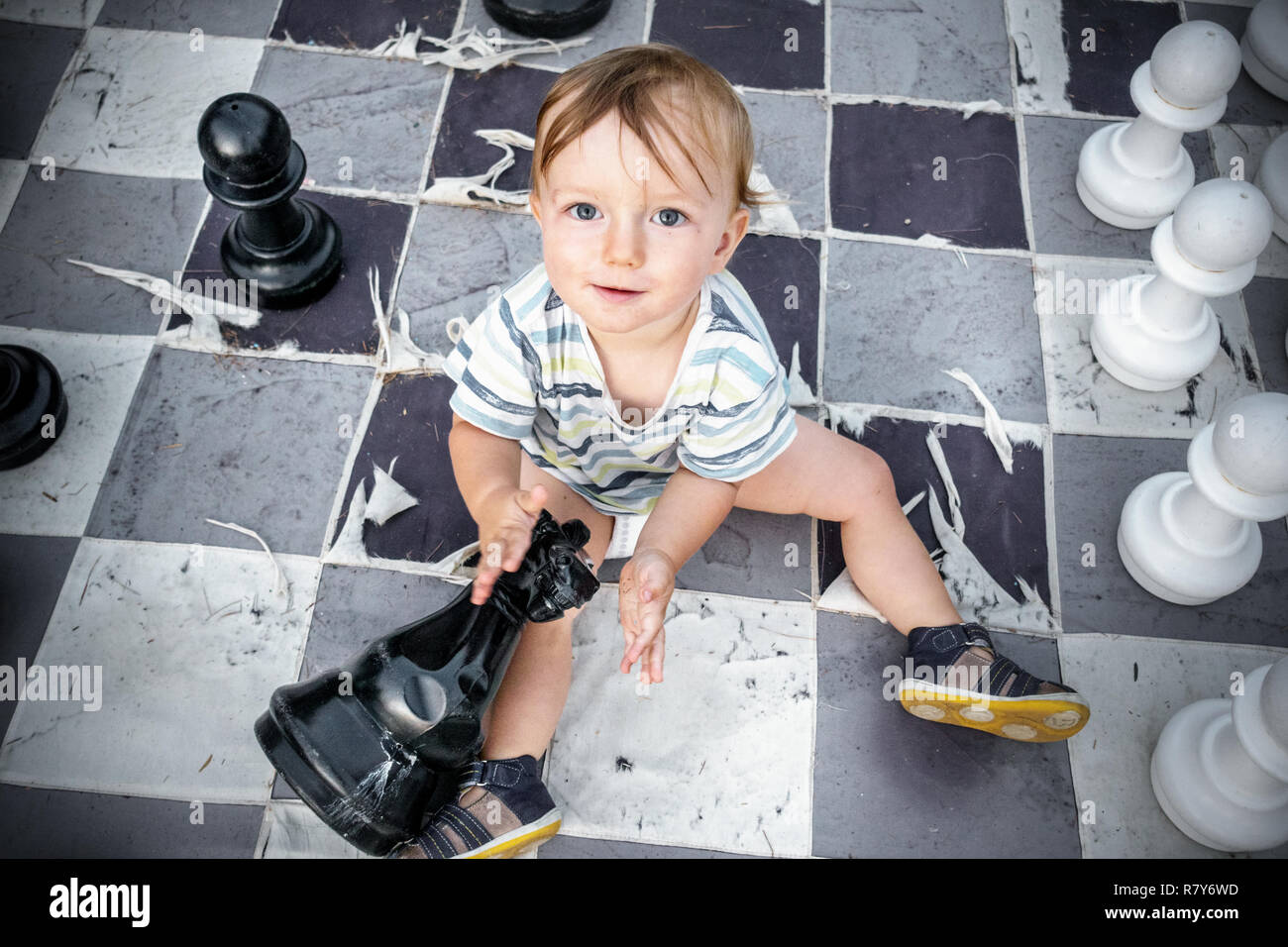 Boy sitting on chess board Stock Photo