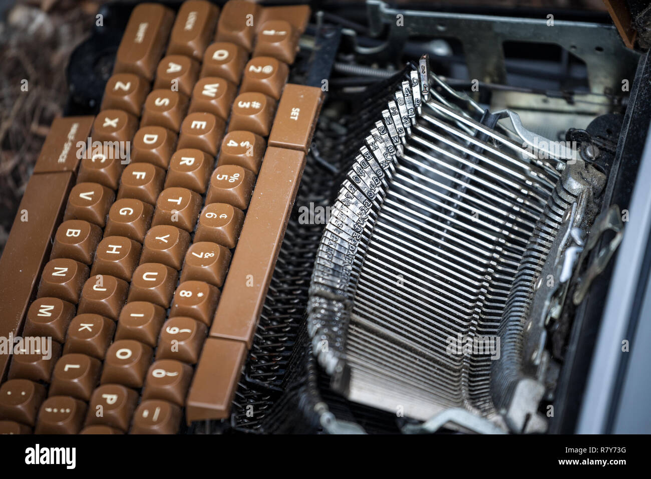 Old and broken typewriter, obsolete, with the blades and the QWERTY keyboard remaining following heavy damage caused by age.   Picture of a vintage ty Stock Photo