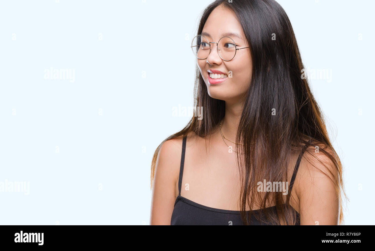 Young asian woman wearing glasses over isolated background looking away to  side with smile on face, natural expression. Laughing confident Stock Photo  - Alamy