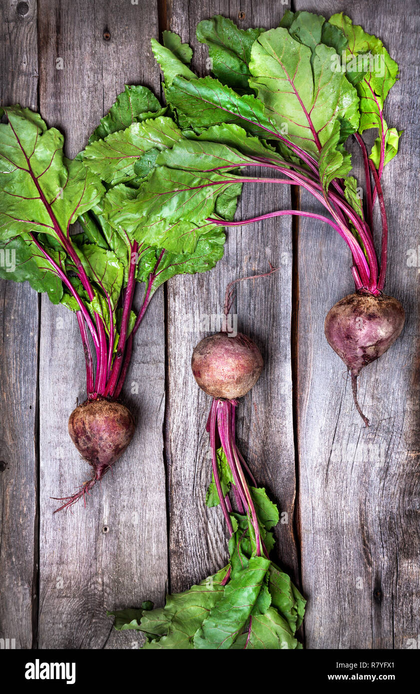 Raw beetroot with green leaves on wooden background Stock Photo