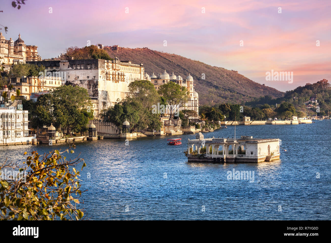 Lake Pichola with City Palace view at pink sunset sky in Udaipur, Rajasthan, India Stock Photo