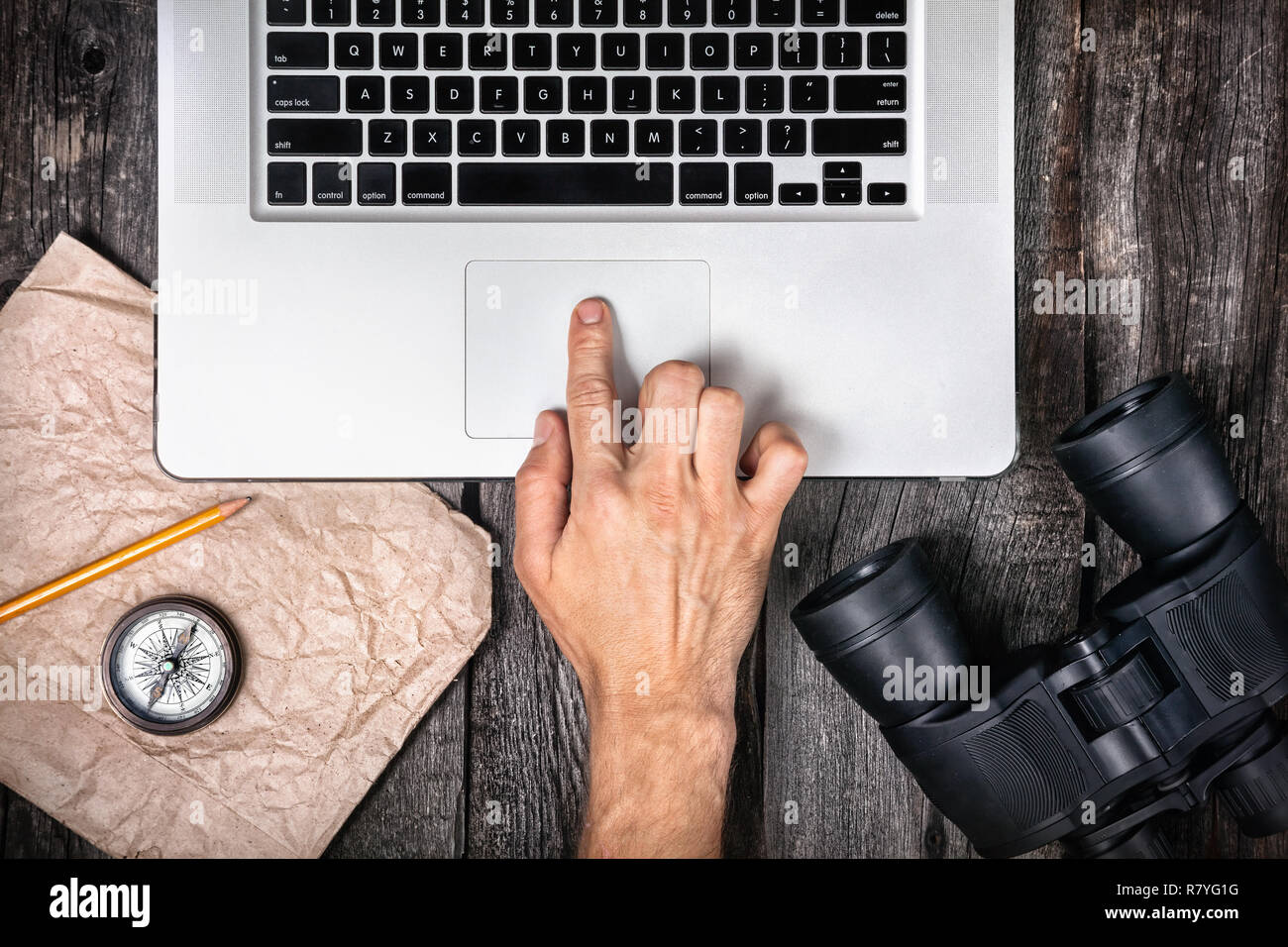 Traveler preparing to his trip with laptop, compass and binocular on the wooden background Stock Photo
