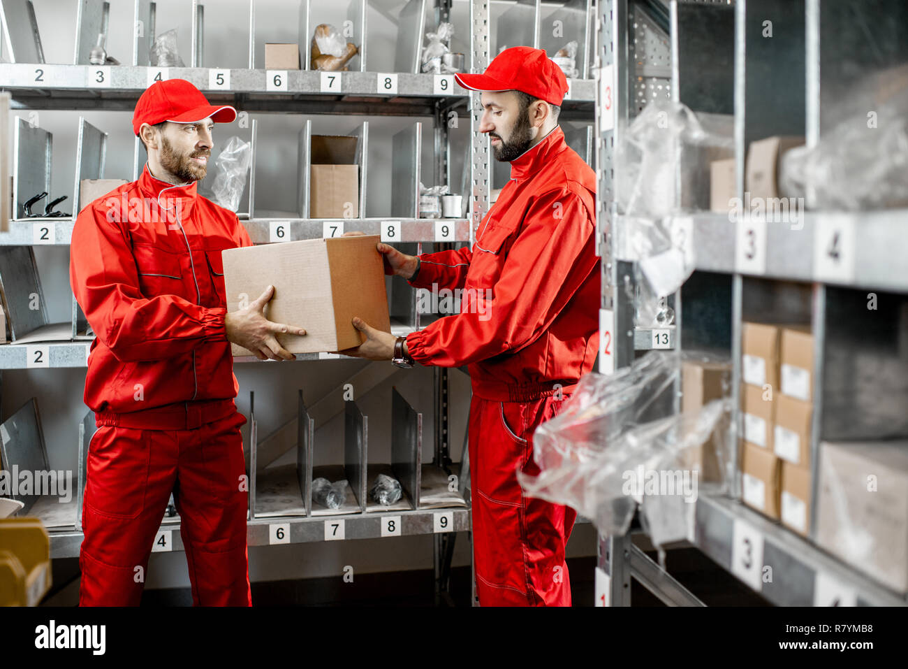 Warehouse workers in red uniform during the work in the storage Stock Photo