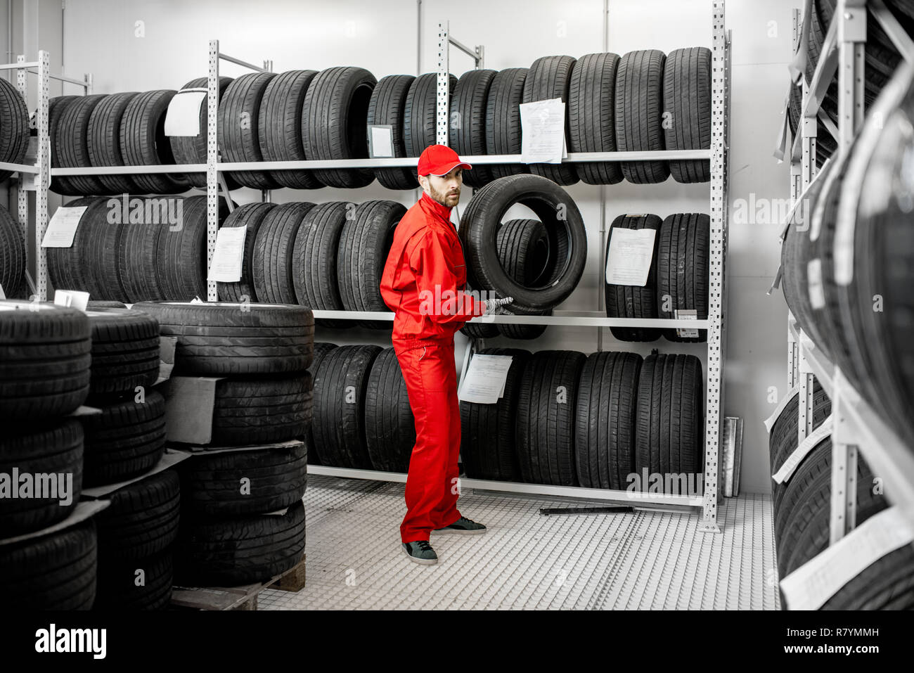 Worker or salesman taking tires from the shelves of the warehouse of
