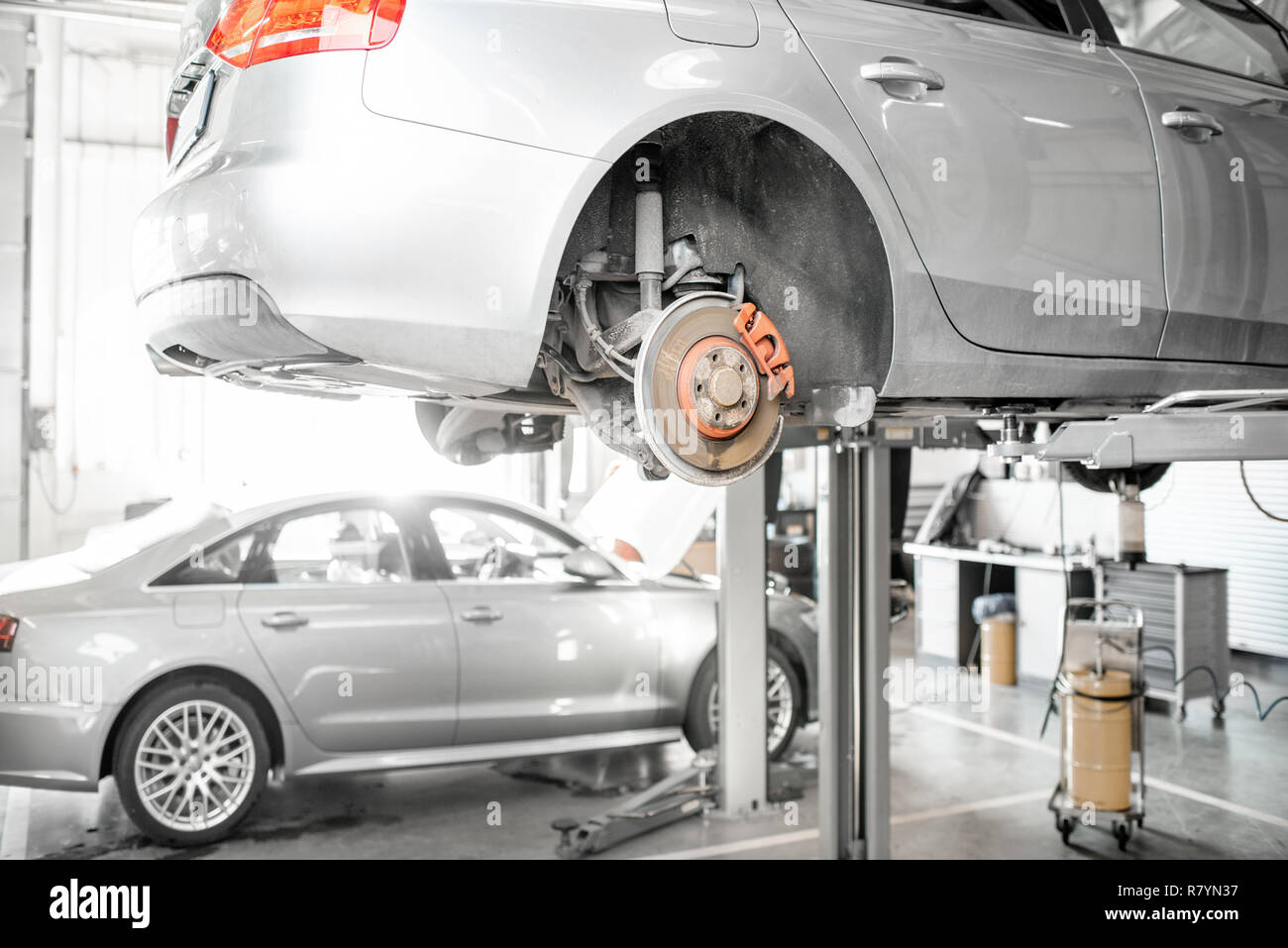 Car standing on the hoist during the diagnostics at the car service Stock Photo