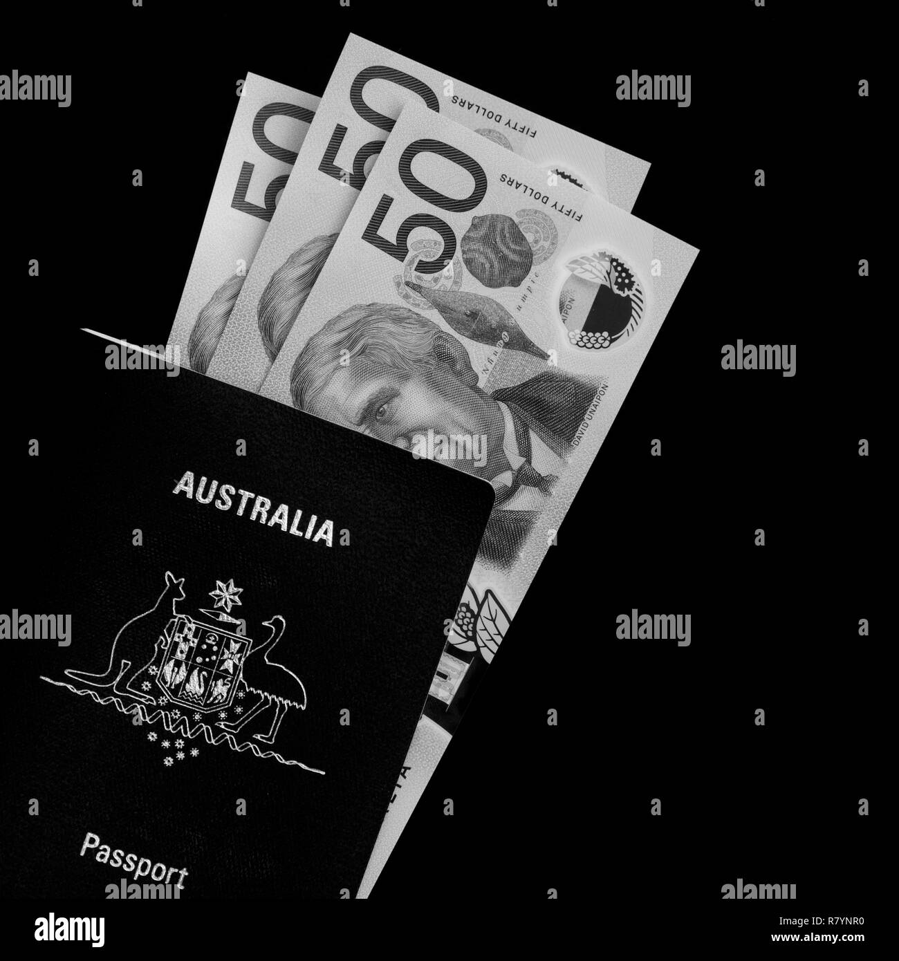 Australian fifty dollar notes and an Australian passport in black and white. Stock Photo