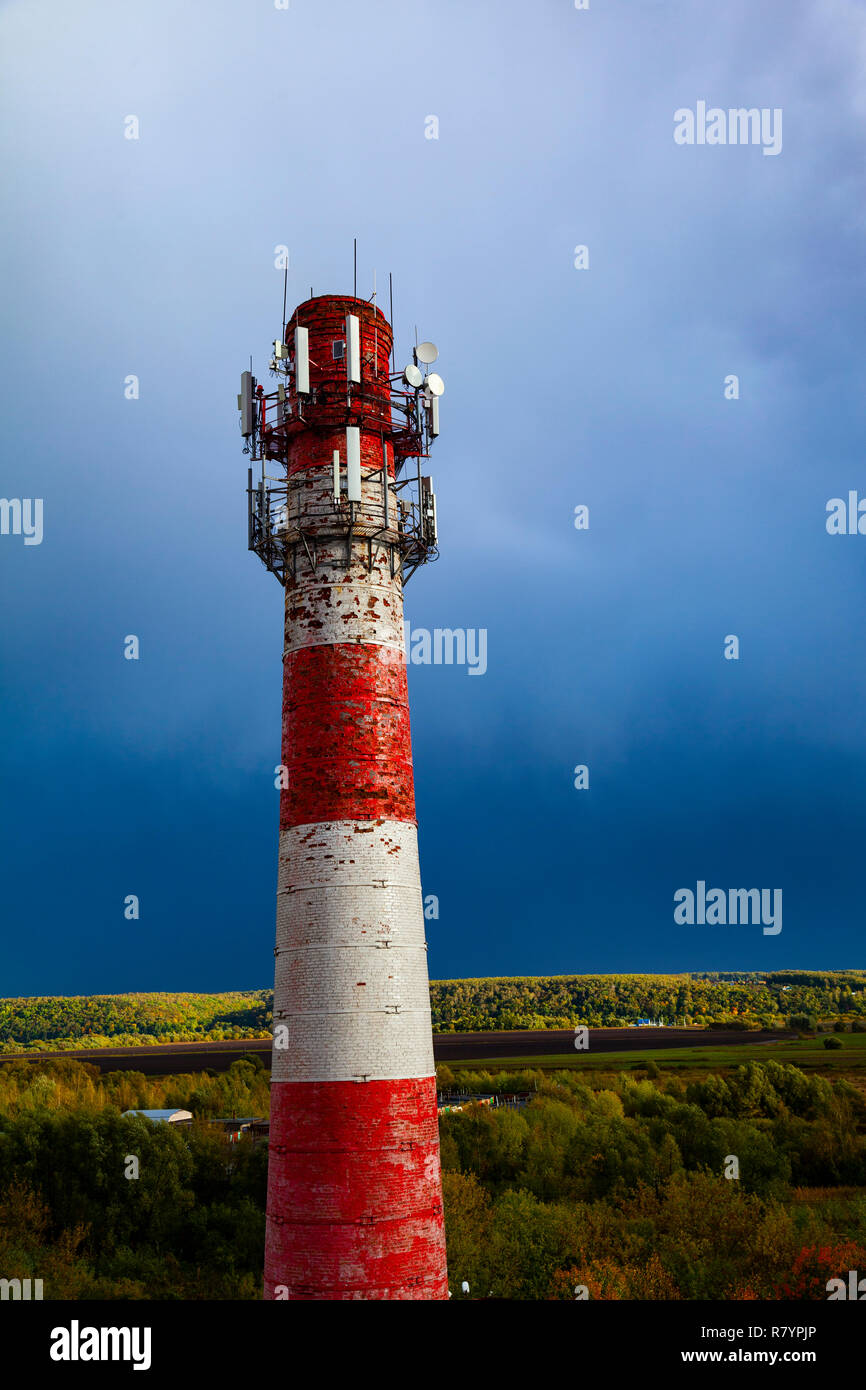 Red and white old pipe on a background of blue sky. Stock Photo