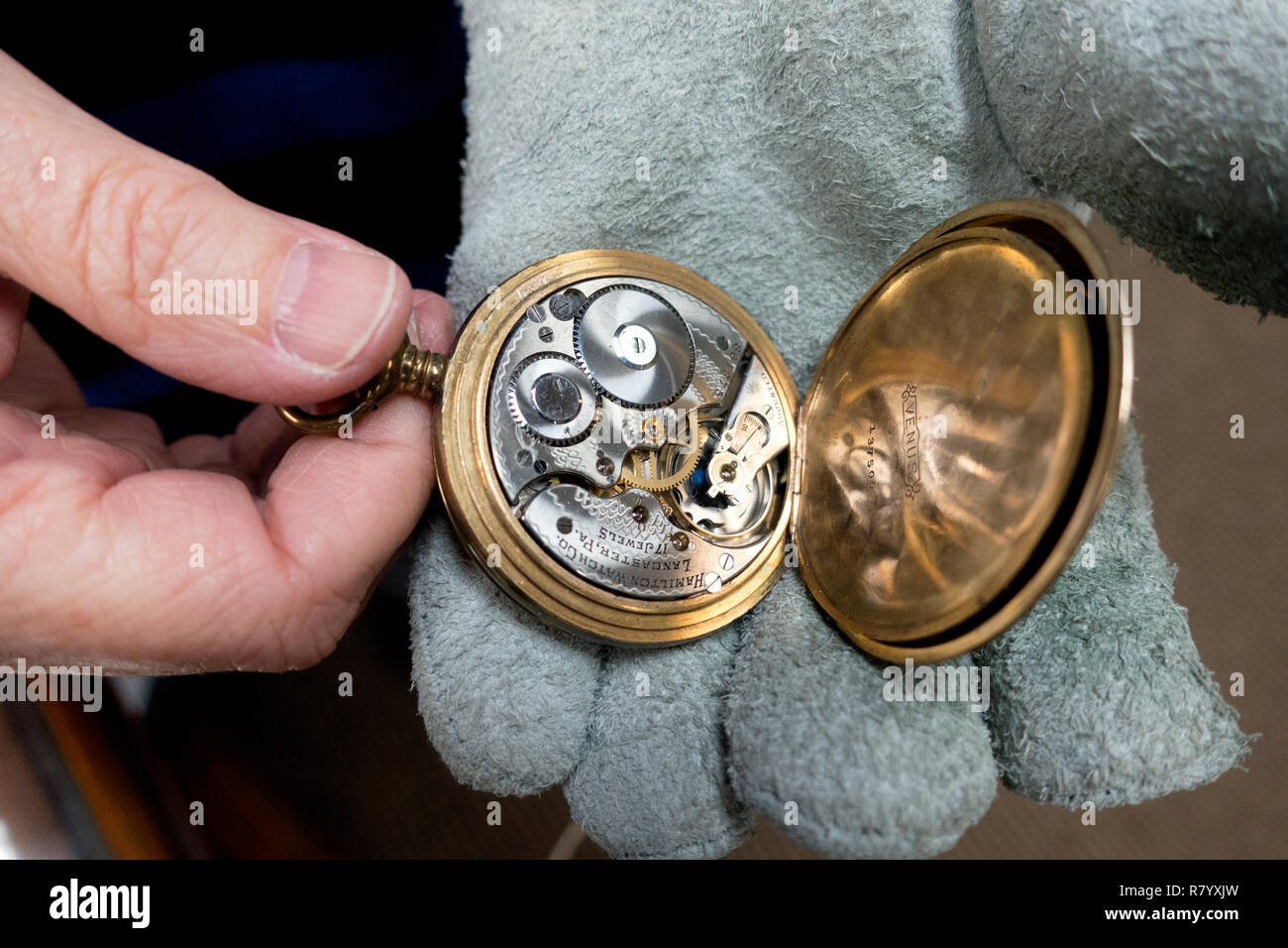 Watch dealer appraising a pocket watch showing the inside workings. St
