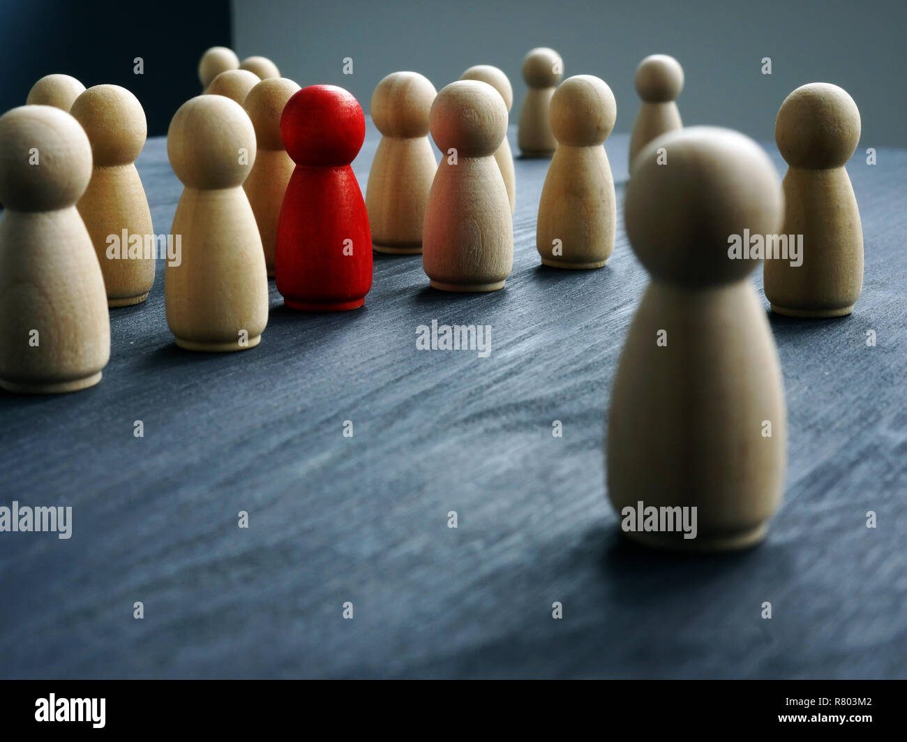 Be Unique, think differently, individuality. Wooden figures and one red figure. Stock Photo