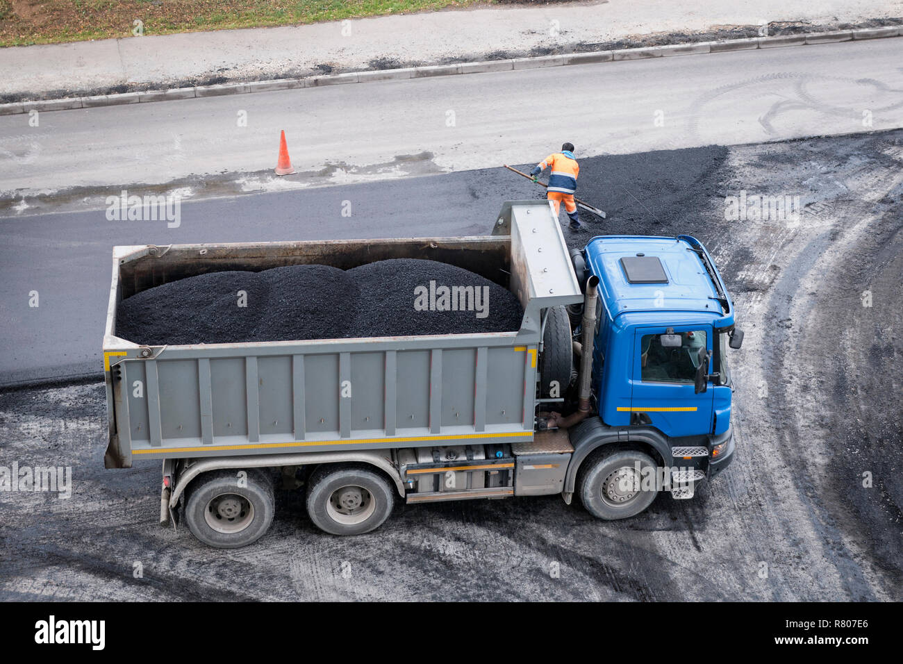 Dumper truck with fresh asphalt. Road construction working. Road renewal process. High angle view Stock Photo