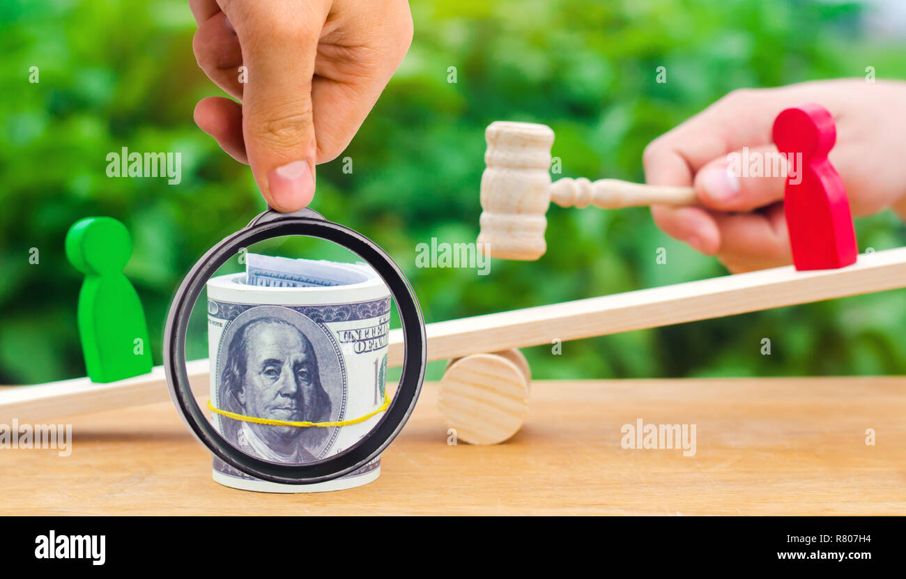 wooden figures of people on scales and dollars between them. a dispute between two businessmen. trial. debt restructuring. wage arrears. protection of Stock Photo