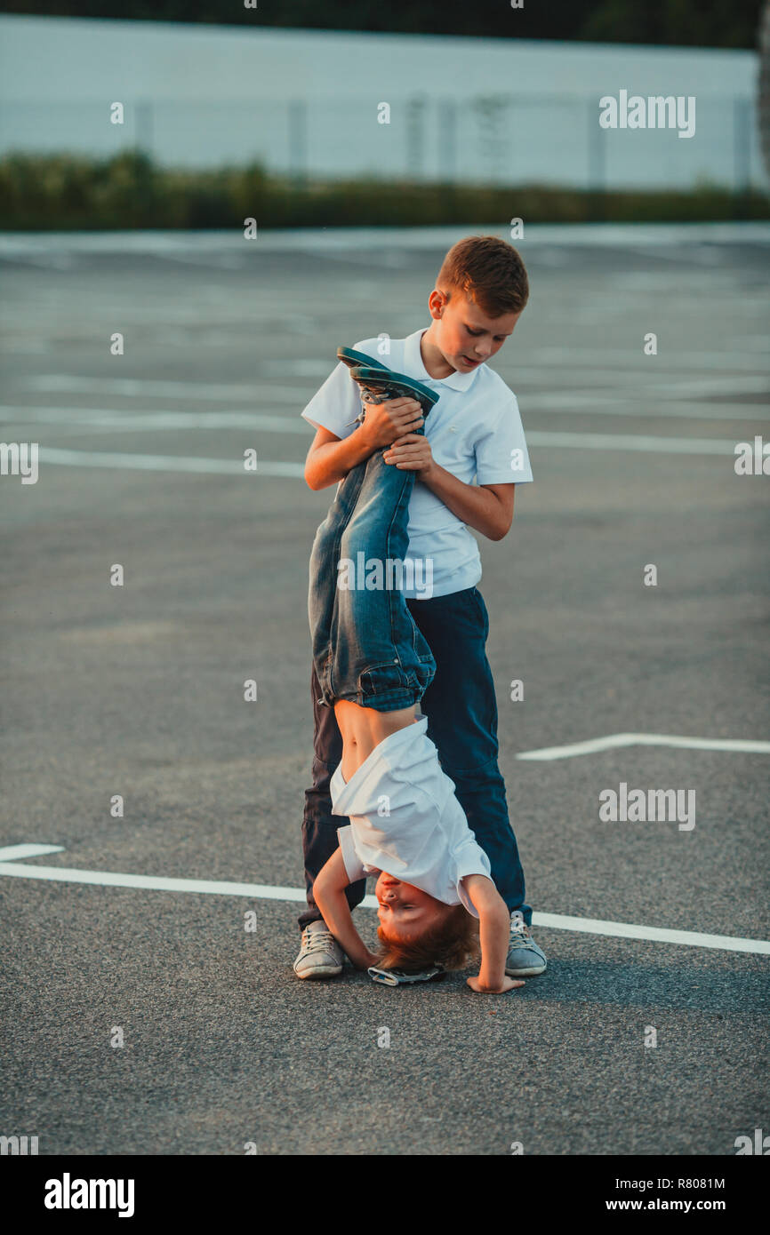 The boy standing upside down outdoor in the summer Stock Photo