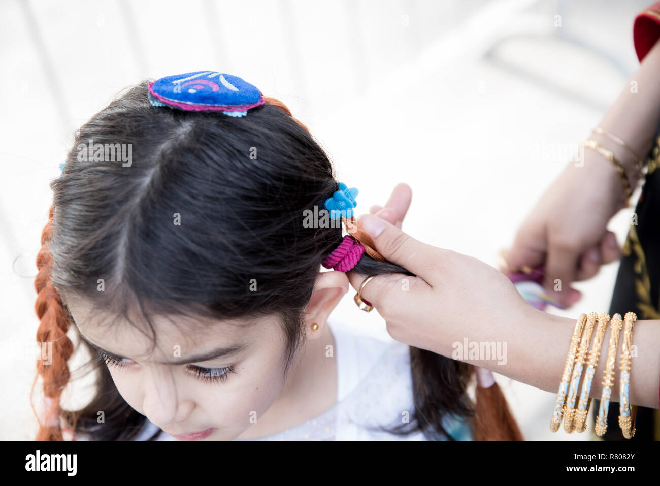 A Little Girl Is Getting Prepared By Her Mother While