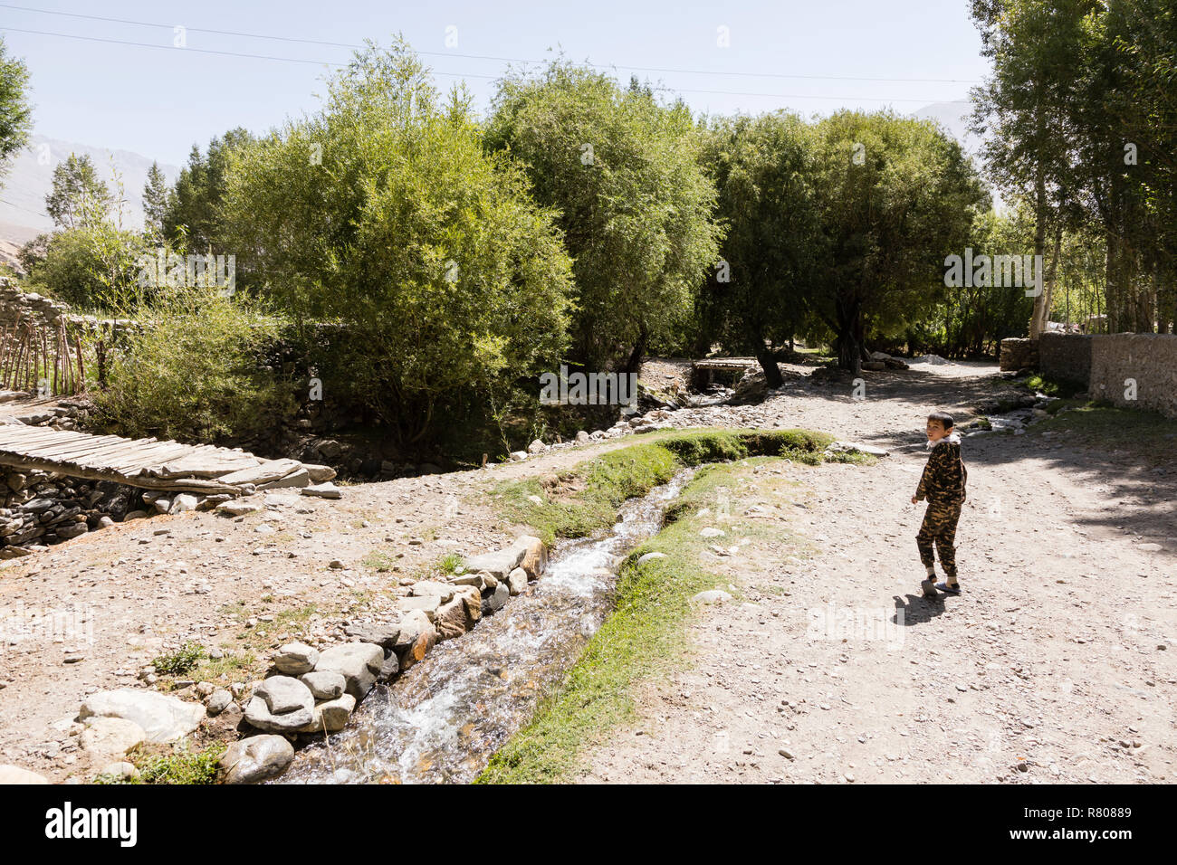 Vrang, Tajikistan August 24 2018: A Tajik boy looks back on a road in a village in the Wakhan valley in Tajikistan Stock Photo