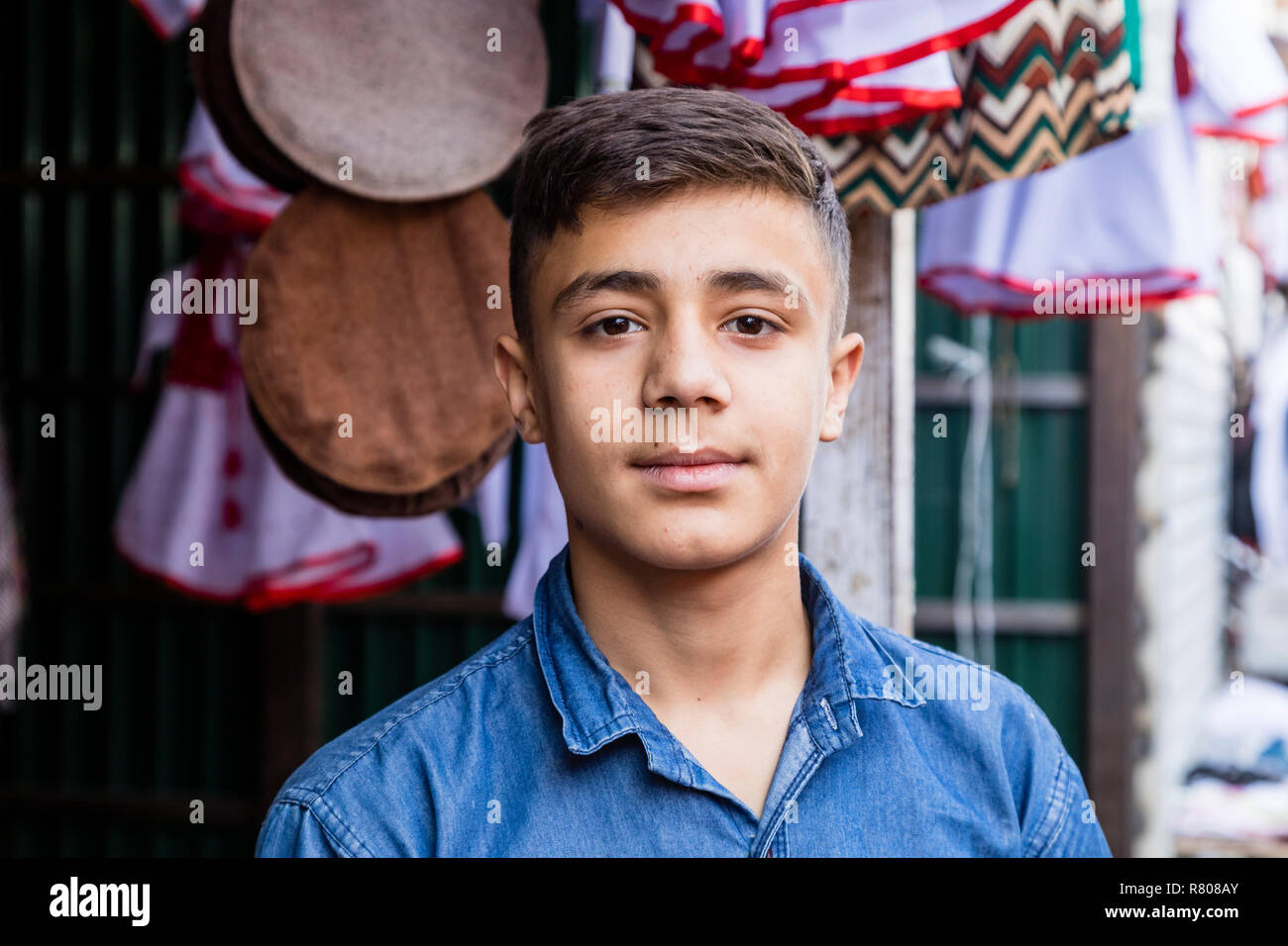 Khorog, Tajikistan August 25 2018: Handsome boy is standing in front of his stall, waiting for buyer of his wares, Khorog, Tajikistan Stock Photo