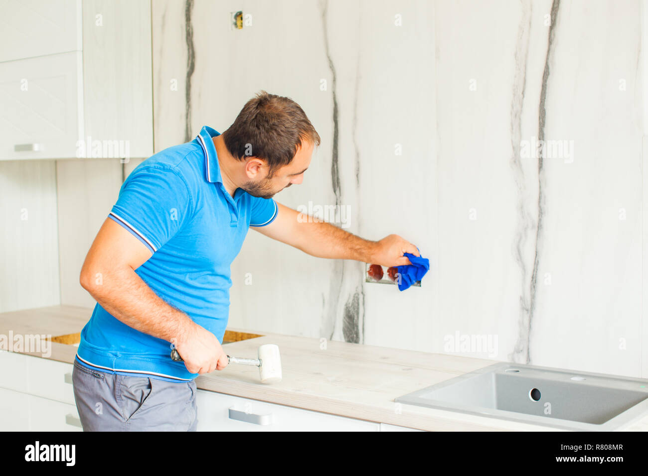 Skilful husband cleaning after self kitchen renovation Stock Photo