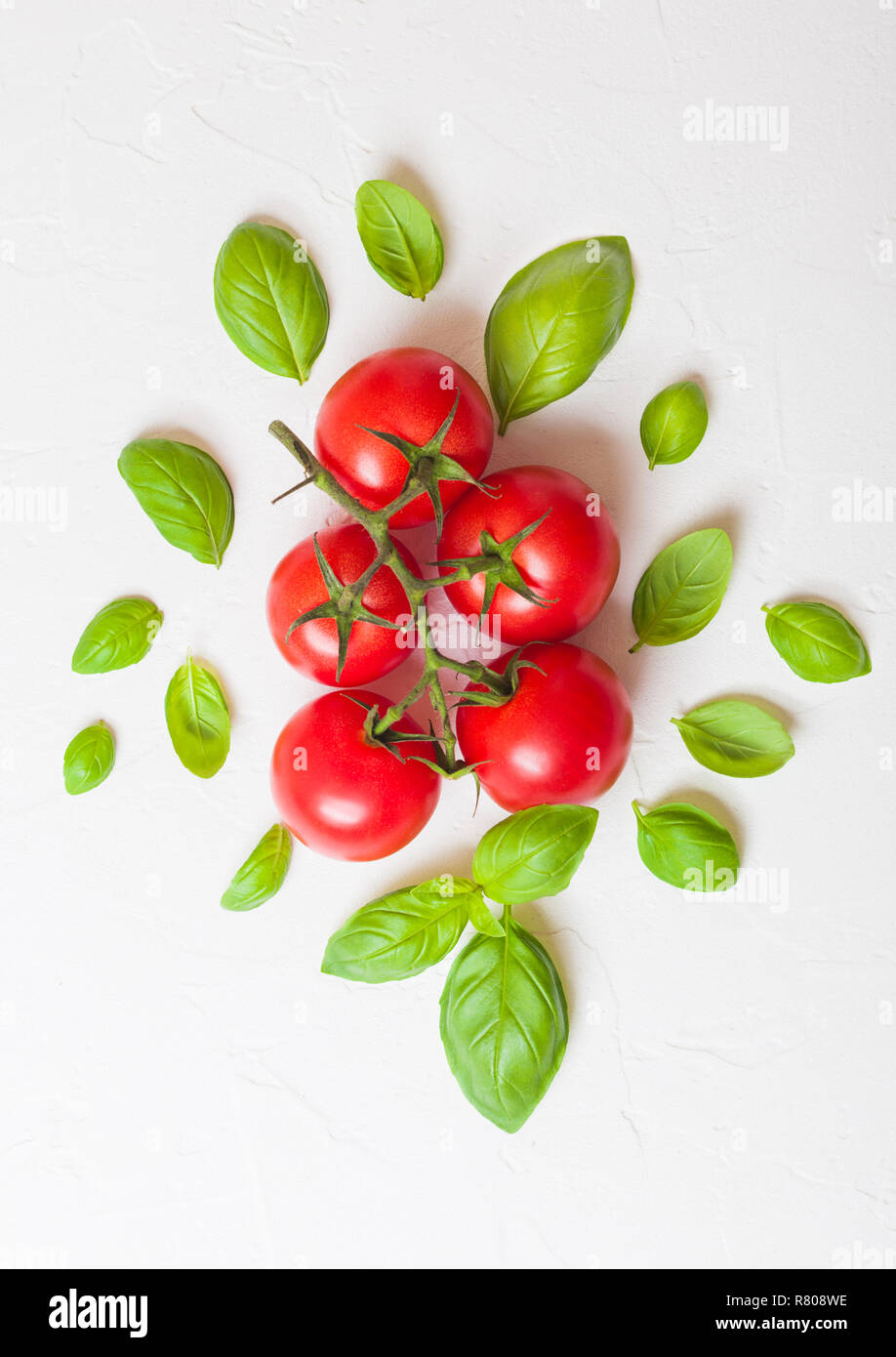 Organic Cherry Tomatoes on the Vine with basil and pepper on white ...