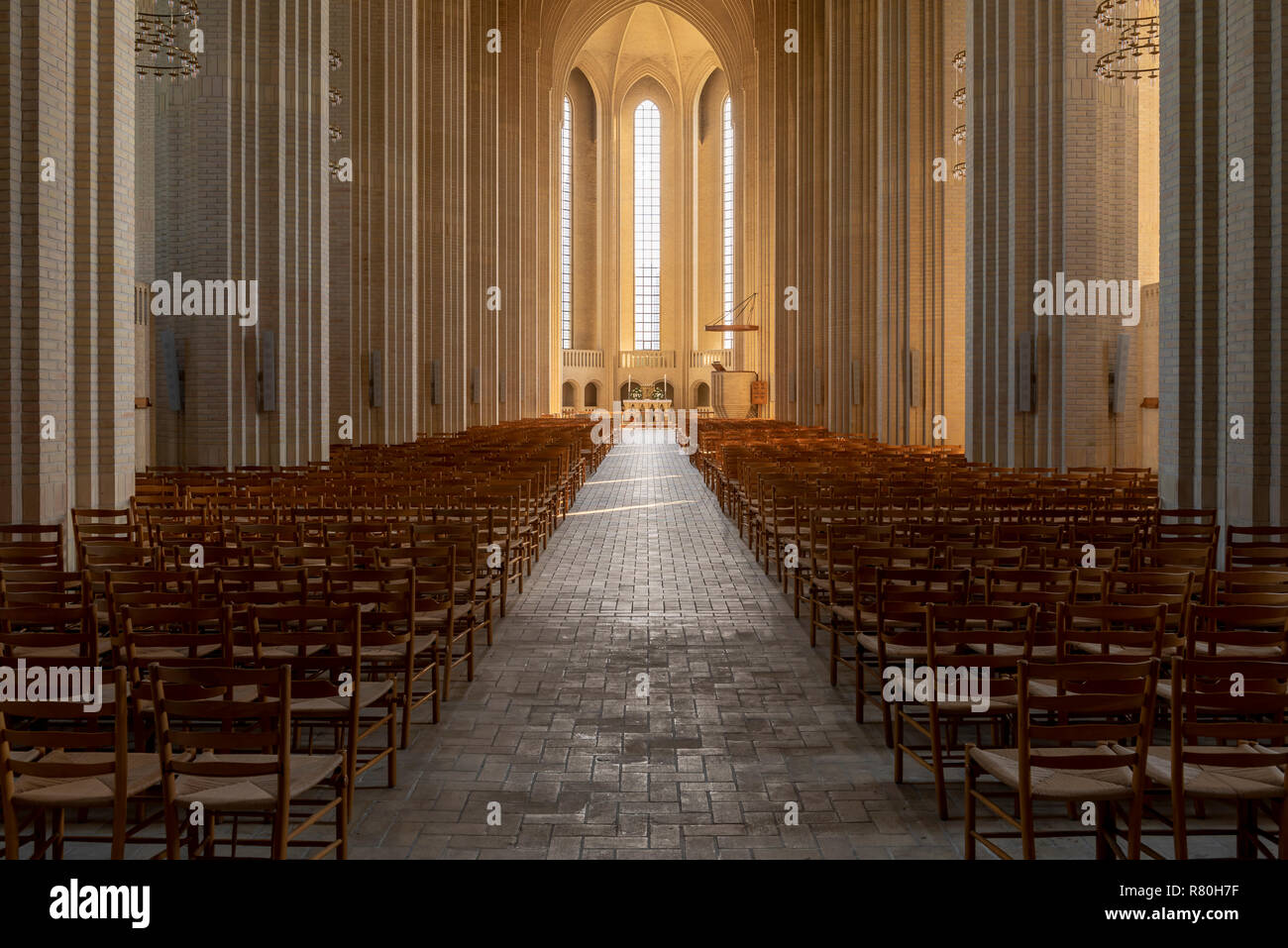 Copenhagen, Denmark - September 18, 2018: Interior of the Grundtvigs church (kirke) with brick pillars, sunlight and chairs. Stock Photo