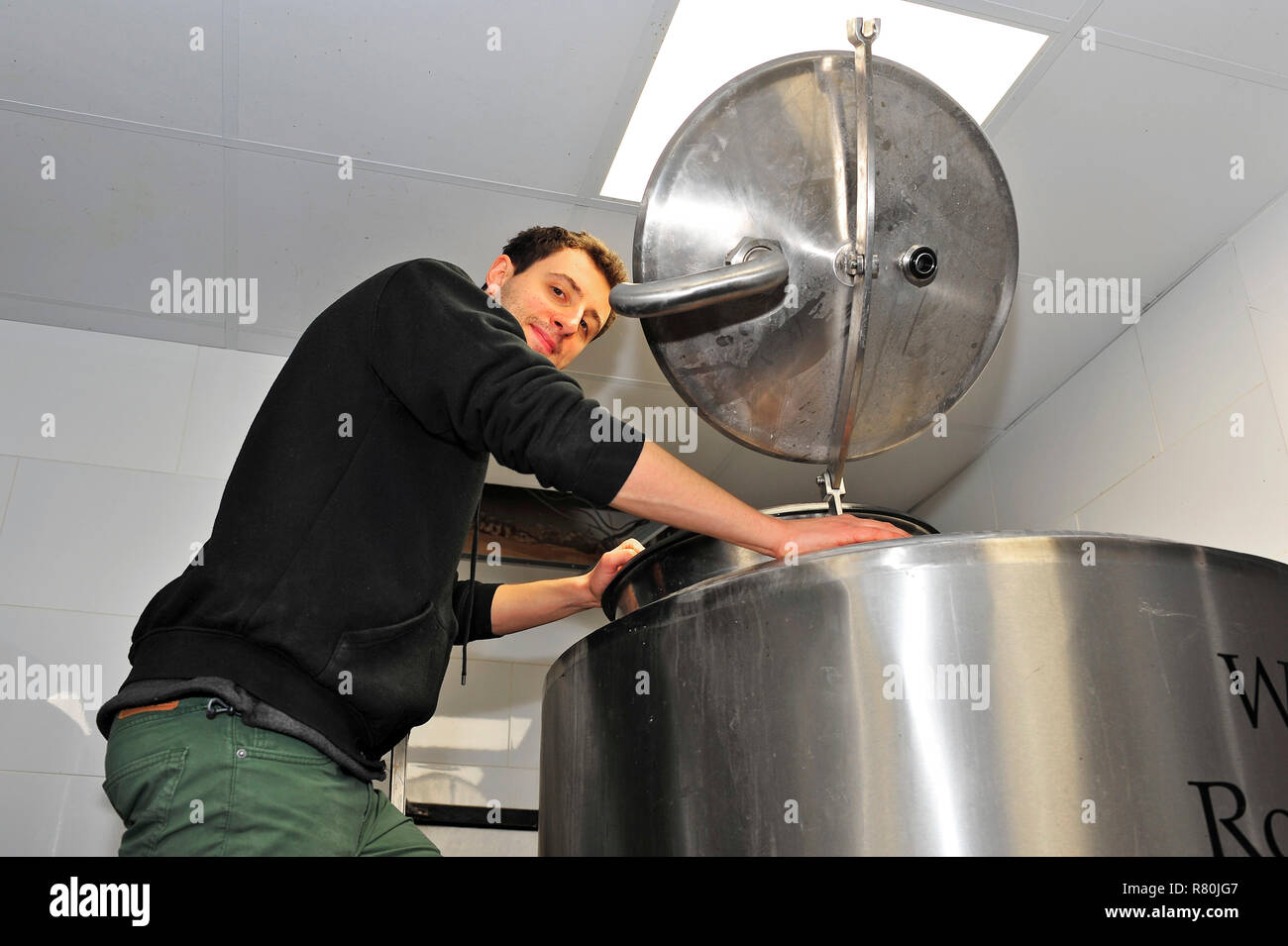 Brewer checking the fermentation vessel at West Coast Rock micro brewery attached to the Brew Room pub,Blackpool Stock Photo
