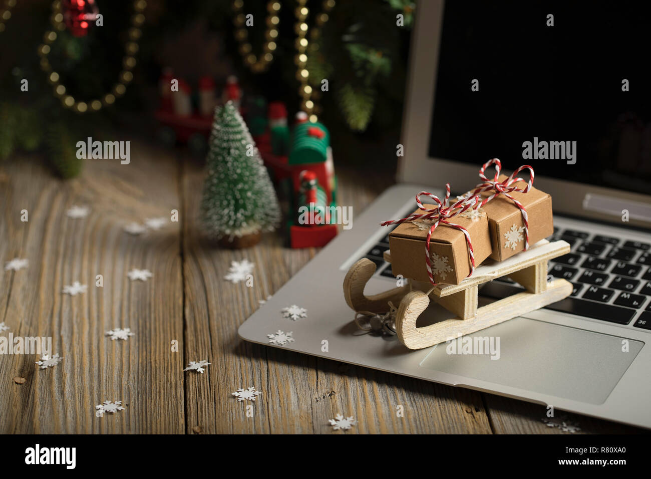 Small Wooden Sleigh With Christmas Presents On A Laptop Closeup