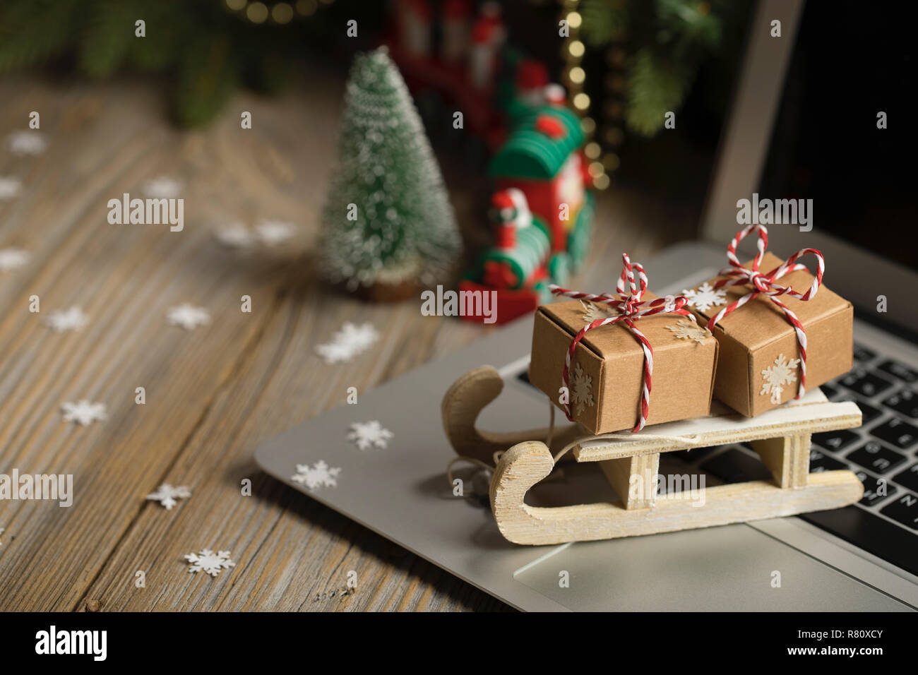 Small Wooden Sleigh With Christmas Presents On A Laptop Closeup