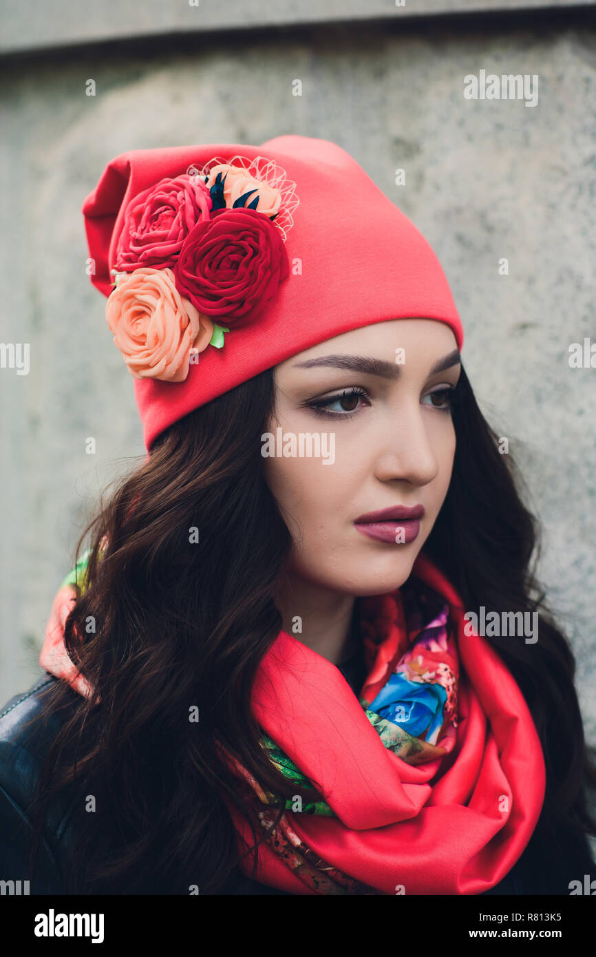 Portrait of funny young girl in the autumn weather in warm clothes and