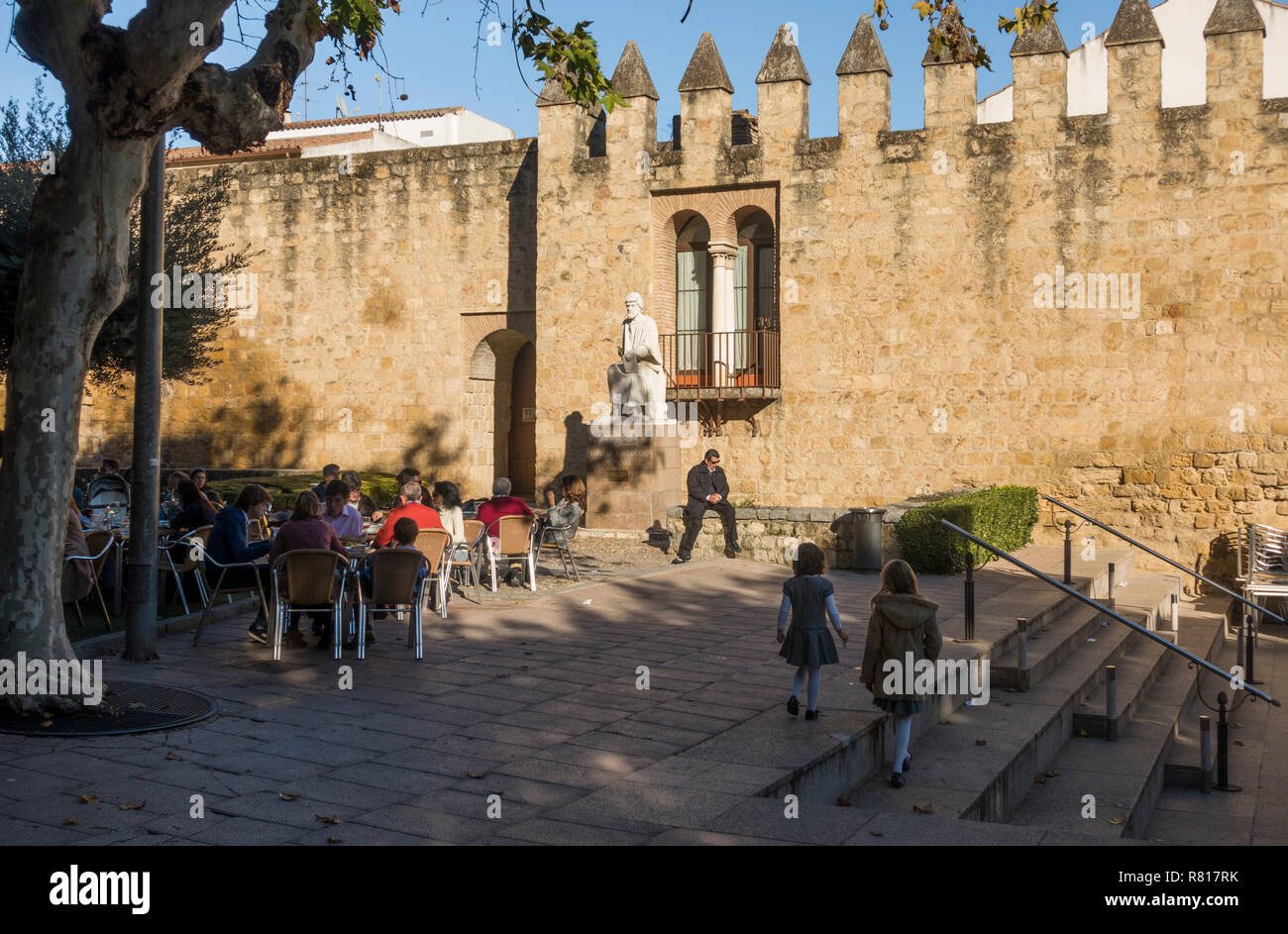 Cordoba, ancient medieval city walls running along the calle Cairuán with terrace restaurant, statue of arab philosopher Averroes, Cordoba, Andal Stock Photo