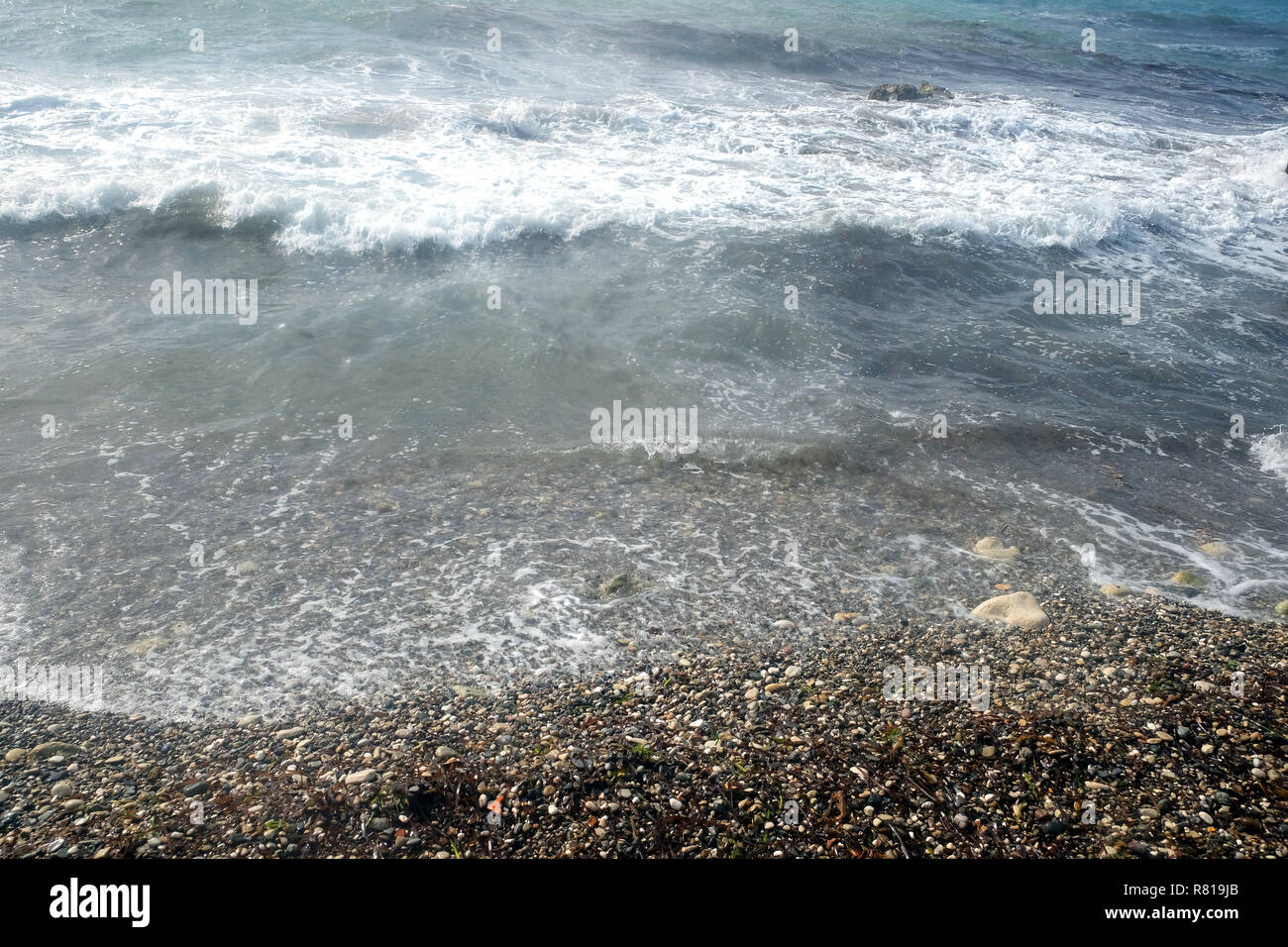 Landscape with sea  waves on the and beach with many small stones on sunny summer day Stock Photo