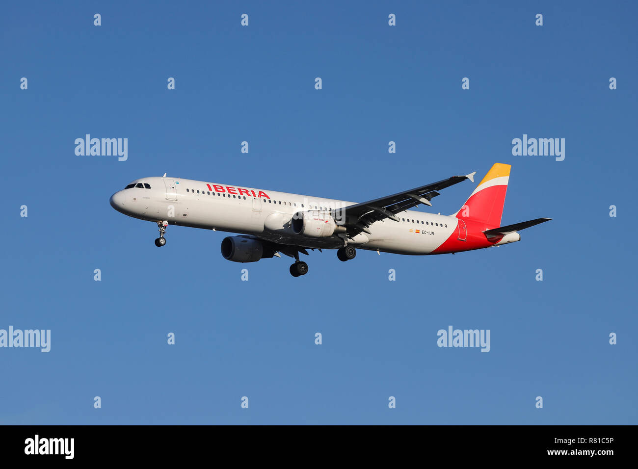 Iberia Airbus A321-200 airplane is seen landing at the London Heathrow airport in England. The aircraft has the name Mérida with configuration of 200 economy seats, with registration EC-IJN and its equipped with 2 CFM56-5 engines. The airline is a Oneworld aviation alliance member and connects the capital of Spain, Madrid to London. Stock Photo