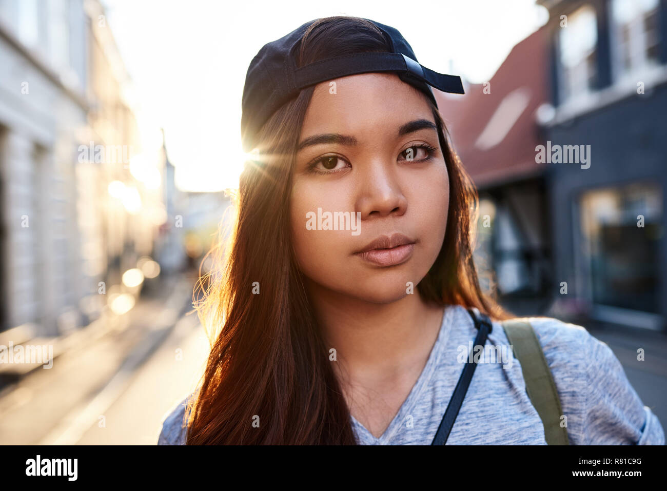 Stylish young Asian woman walking along a city street Stock Photo