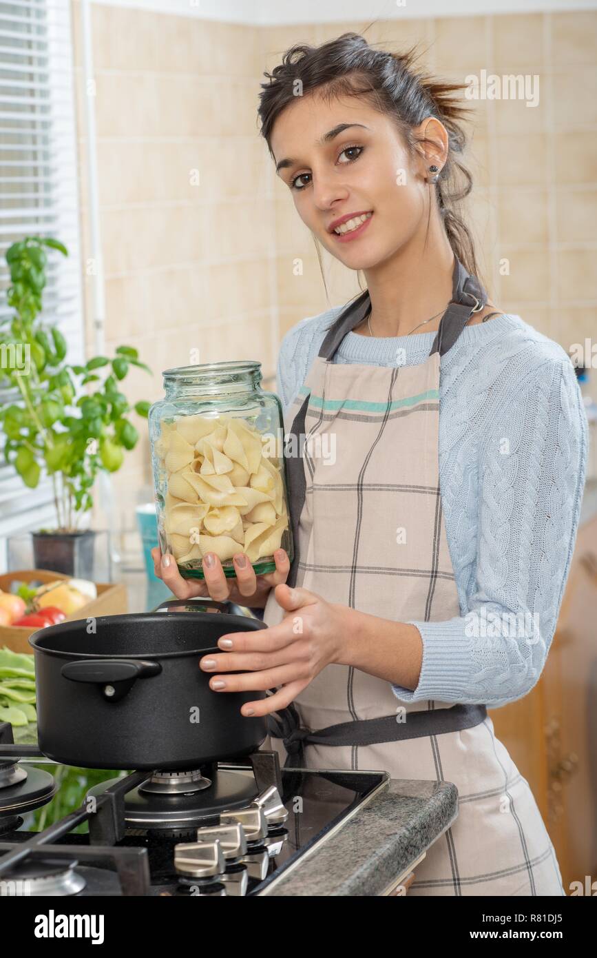 a pretty young brunette woman cooking in the kitchen Stock Photo - Alamy