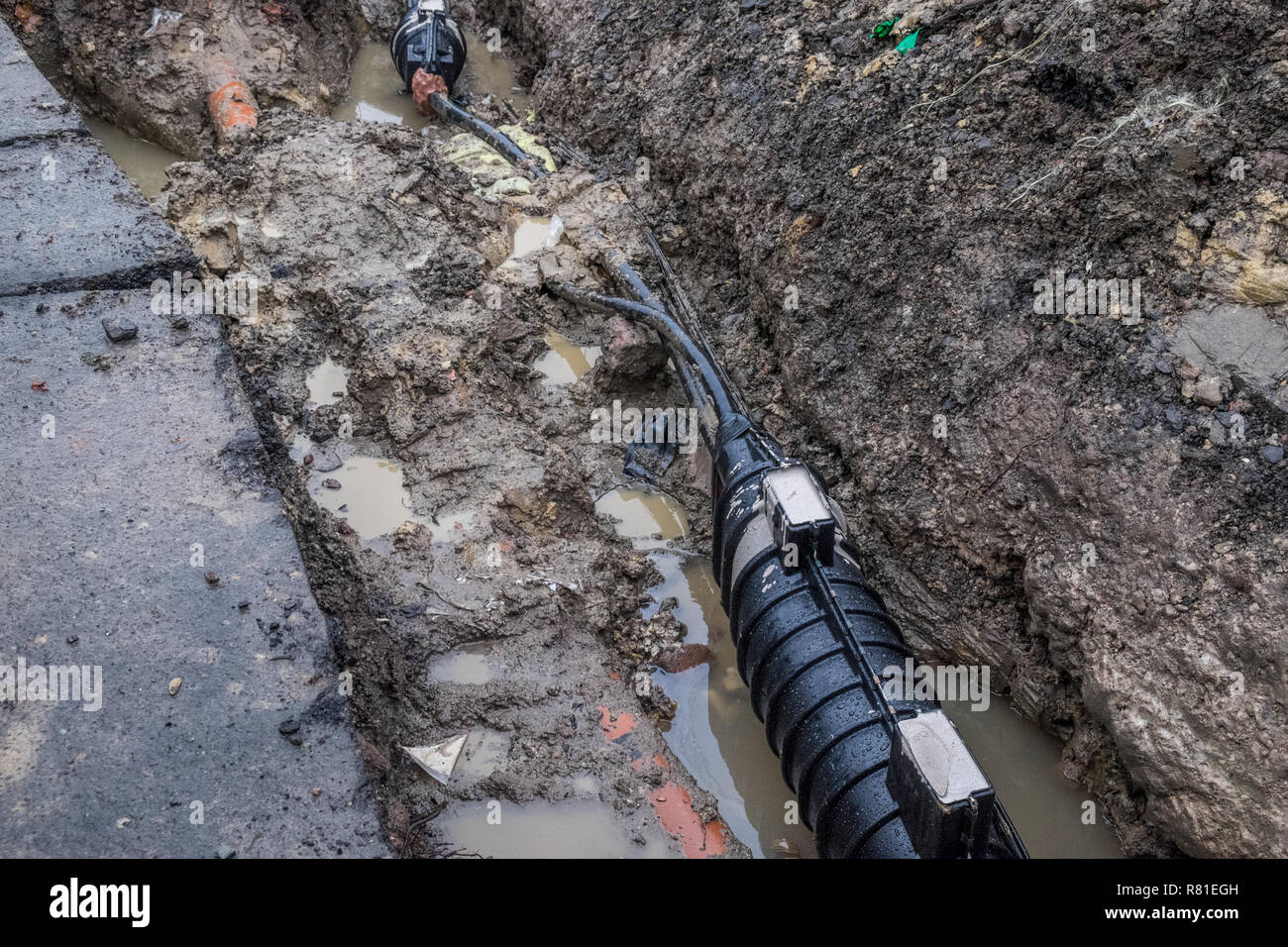 Main power cable repair in trench during heavy rain Stock Photo Alamy
