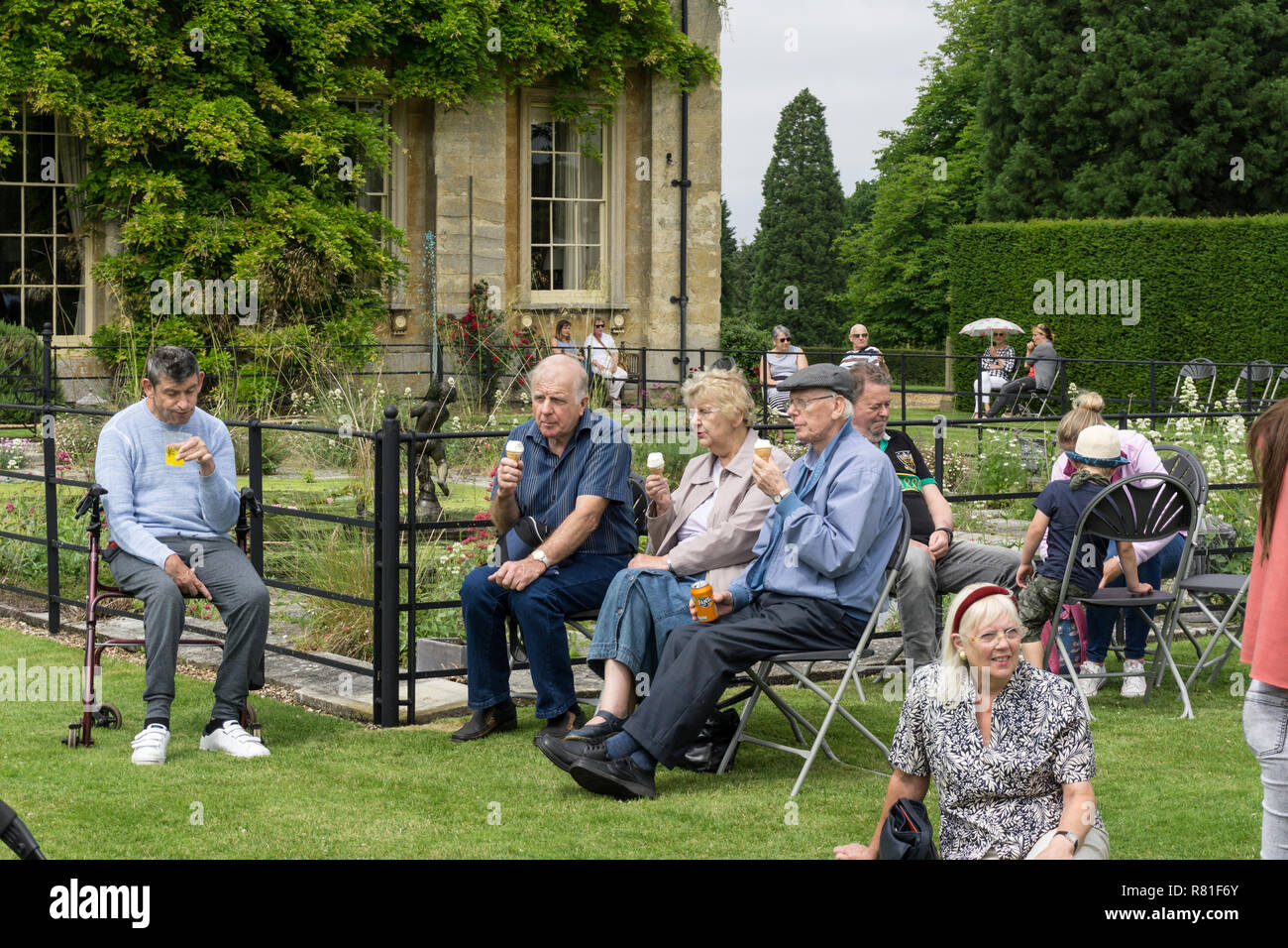 Visitors to a village fete enjoying ice creams and refreshments on a Summer afternoon; Courteenhall, Northamptonshire, UK Stock Photo