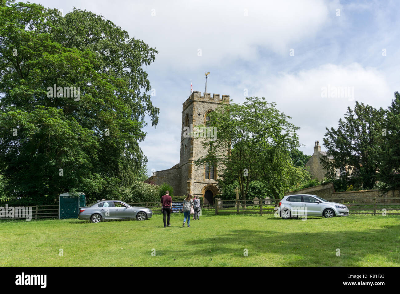 Visitors to the Courteenhall village fete walking to the estate church of St Peter and St Paul, opened for the occasion; Northamptonshire, UK Stock Photo