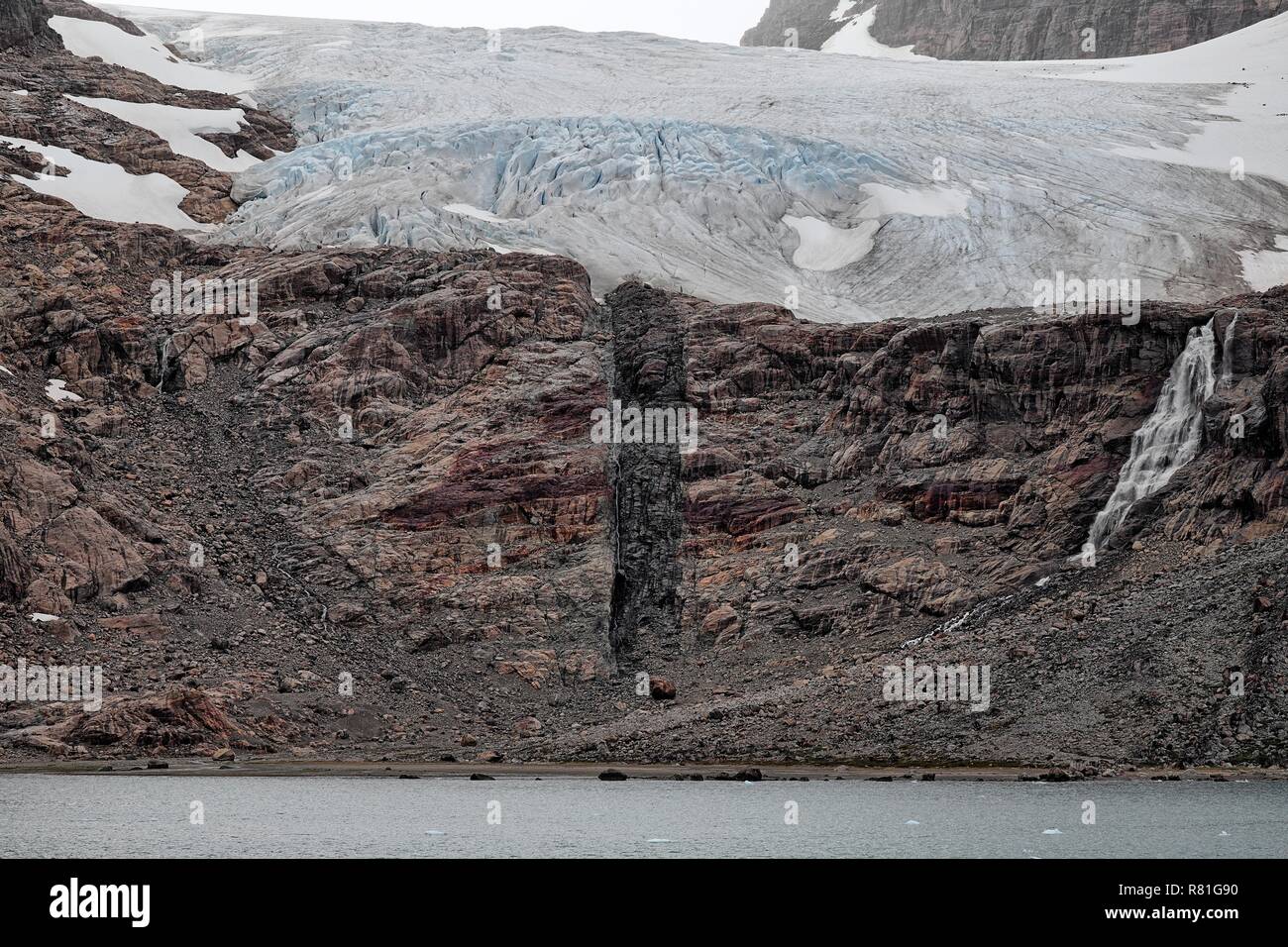 Auf einem Felsen sieht man die Abbruchkante eines Gletschers. In der Mitte erkennt man das Tauwasser, Prinz Christian Sund in Grönland Stock Photo