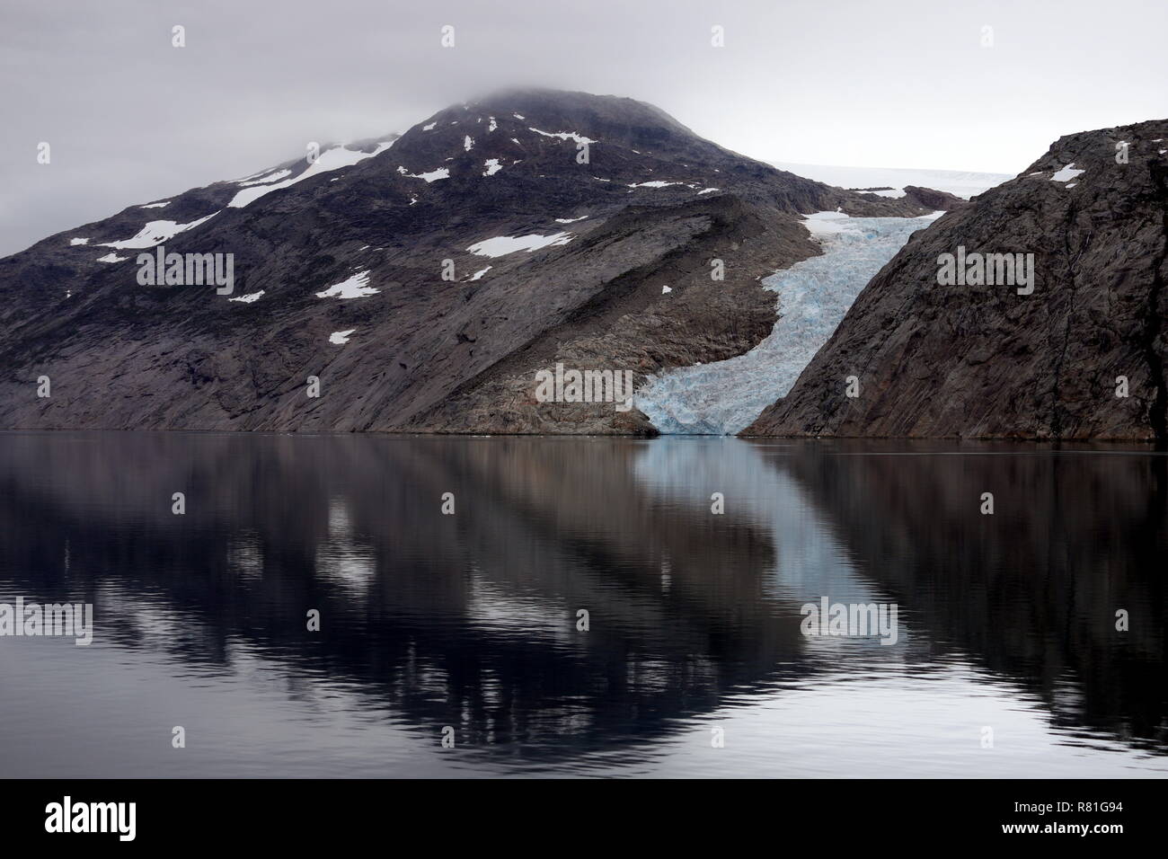 Grönland Prinz Christian Sund: Spiegelglattes Wasser verdoppelt spiegelnd Felsen und Gletscher. Stock Photo
