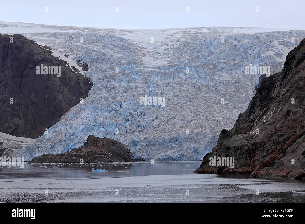 Grönland Christian Sund: Eine Gletscherzunge schiebt sich durch einen Felseinschnitt ins Meer Stock Photo