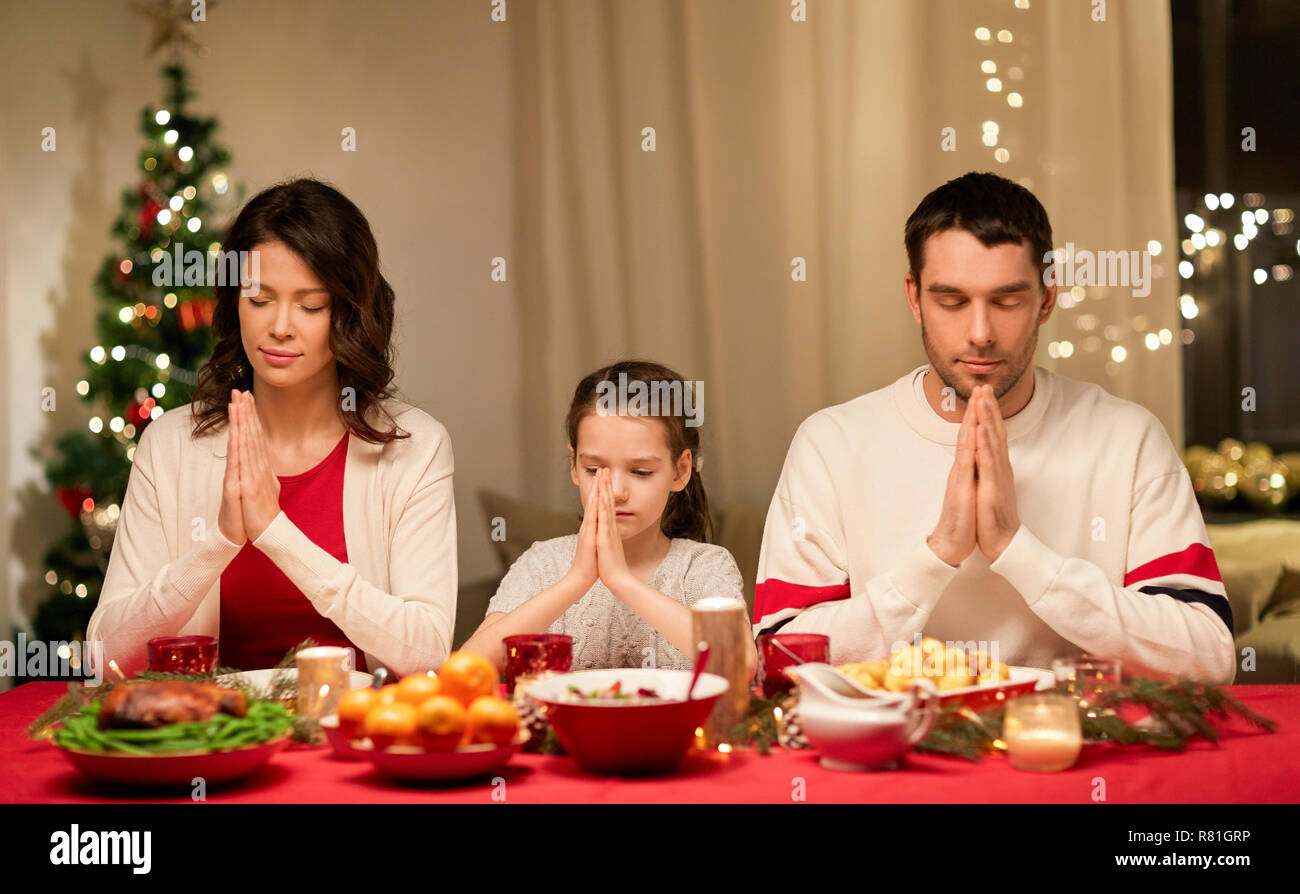 family praying before meal at christmas dinner Stock Photo