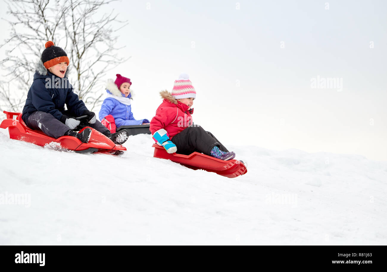 kids sliding on sleds down snow hill in winter Stock Photo Alamy