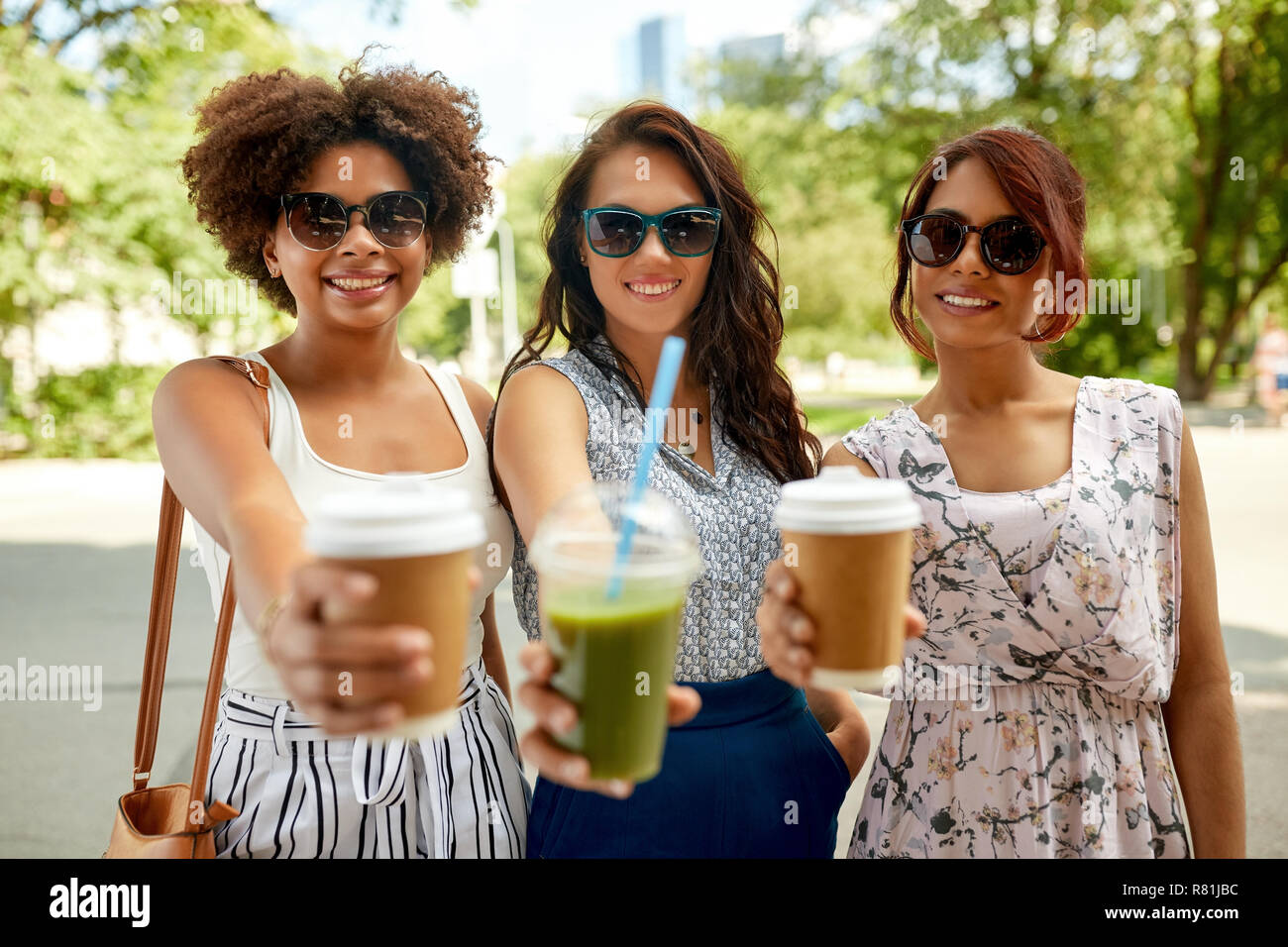 happy women or friends with drinks at summer park Stock Photo