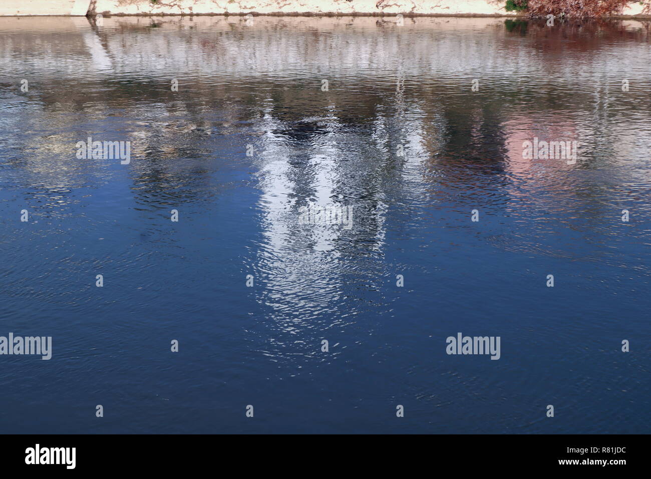 background or wallpaper of water,reflecton of blue sky and white building in river on sunny day,  copy space water texture Stock Photo