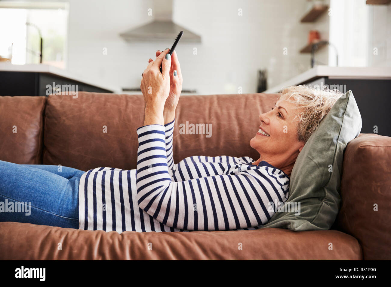 Woman lying on couch jeans hi-res stock photography and images - Alamy