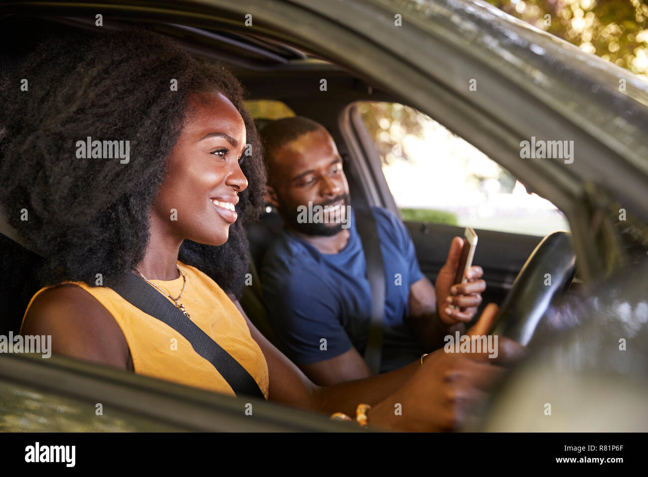 A young black man checks smartphone during a road trip Stock Photo