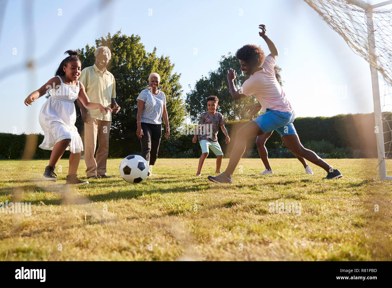Multi generation black family playing football in a garden Stock Photo ...
