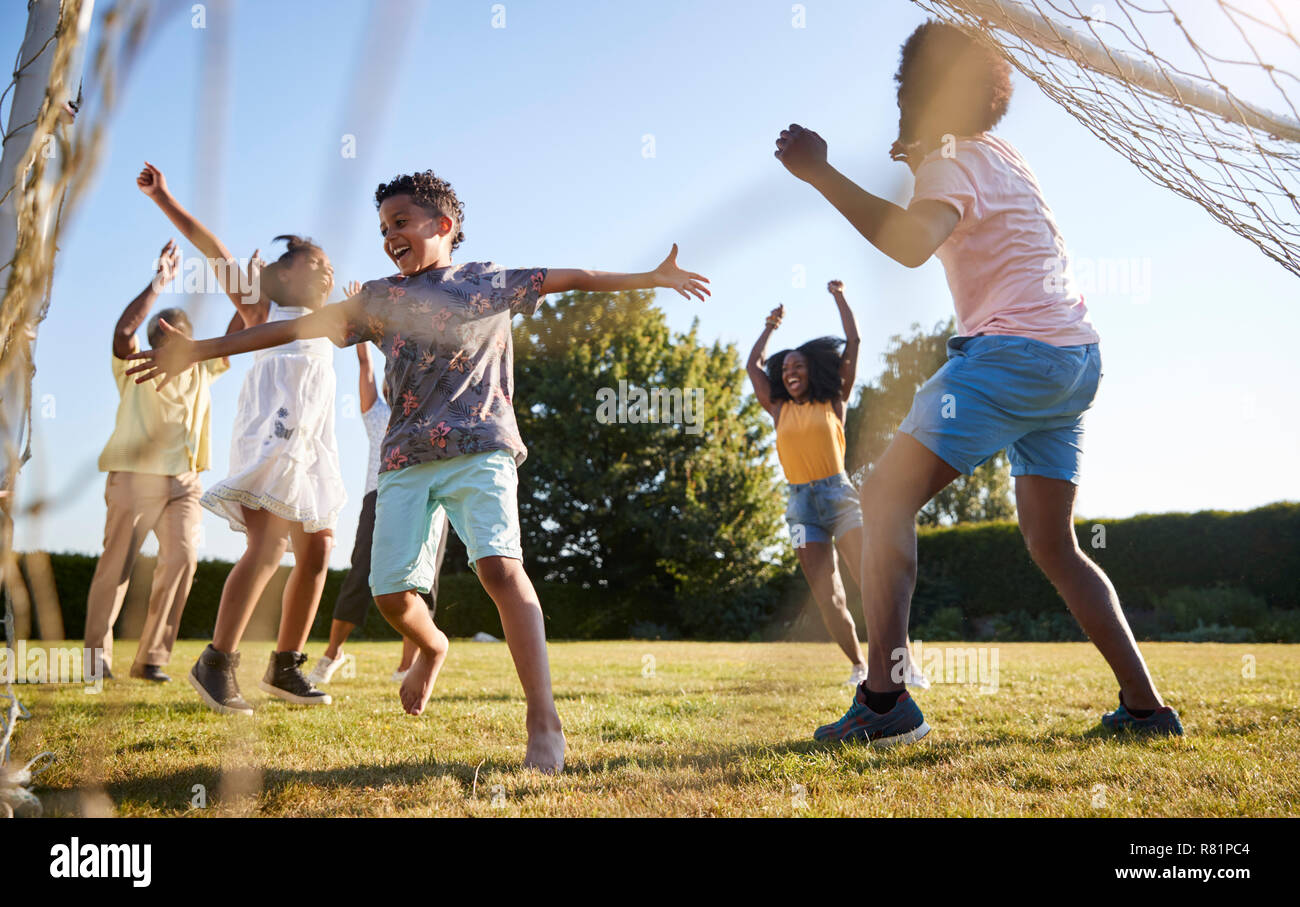 Celebrating goal at a multi generation family football game Stock Photo