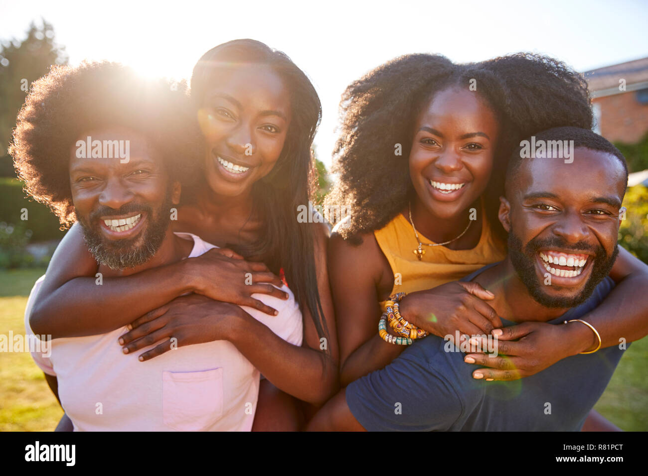 Two black couples, men piggybacking their partners, close up Stock Photo -  Alamy